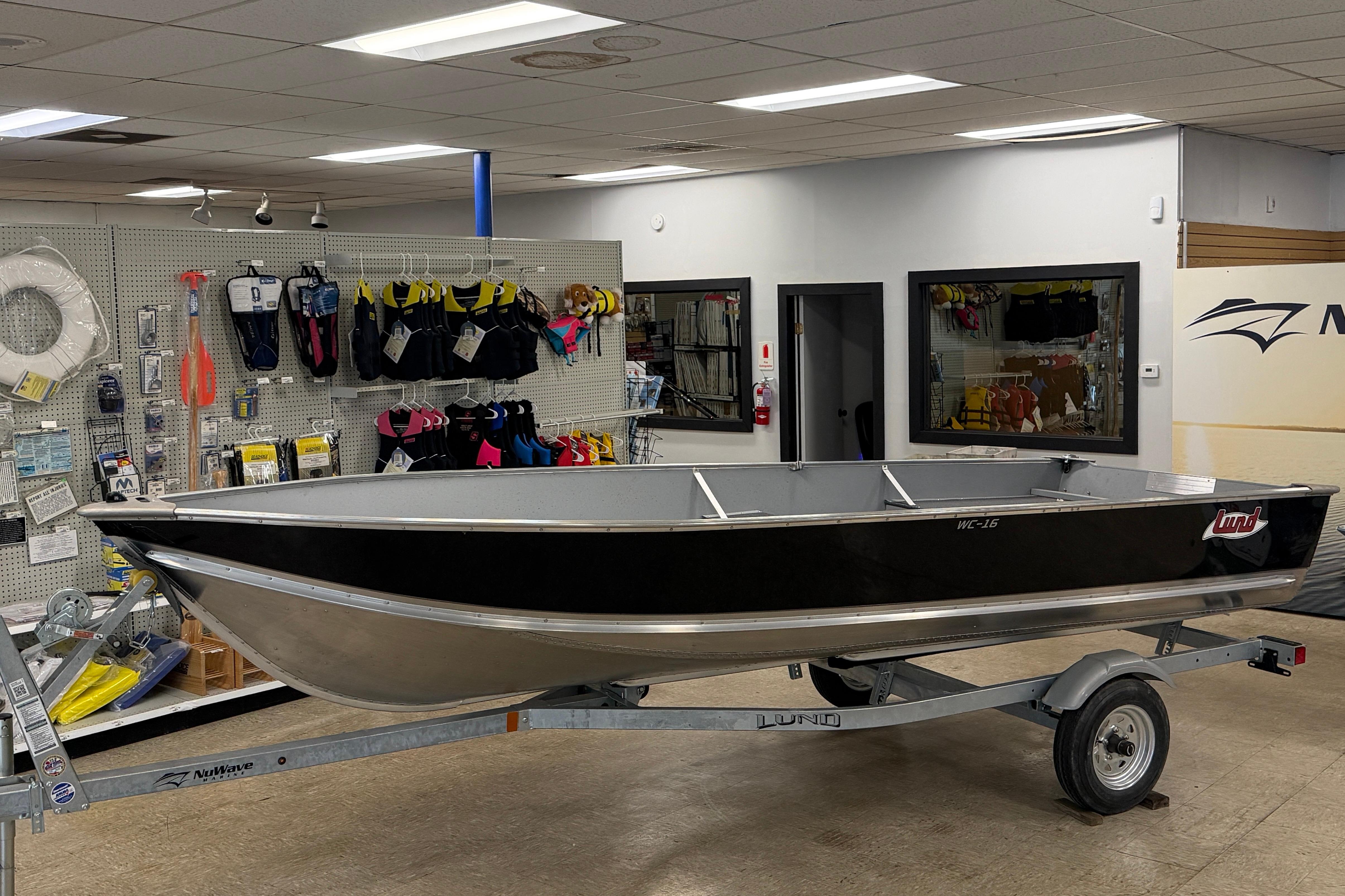 2027 Lund WC 16 boat on trailer in a marine supply store.