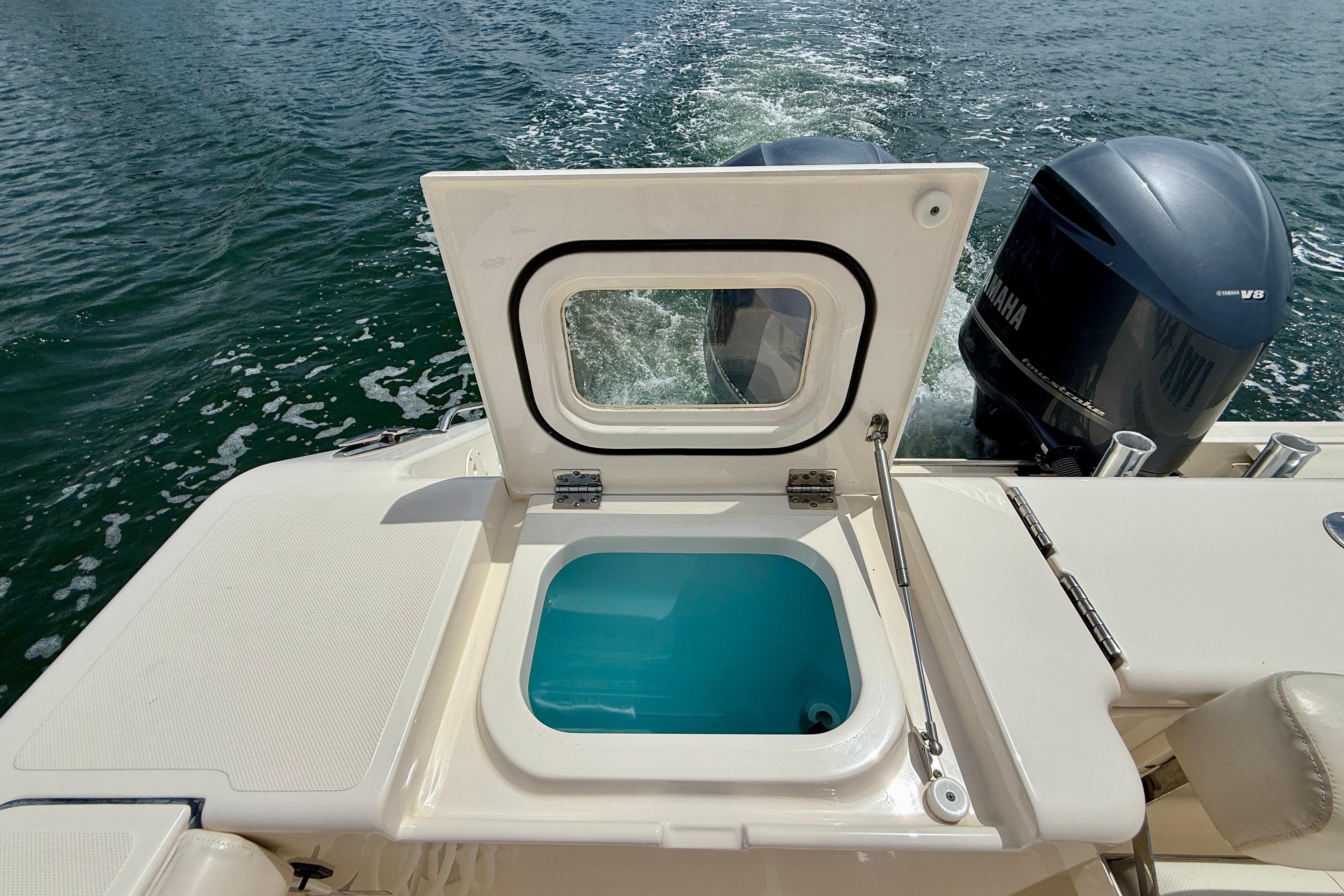 2012 Pursuit OS 345 Offshore boat with open hatch and twin Yamaha engines.