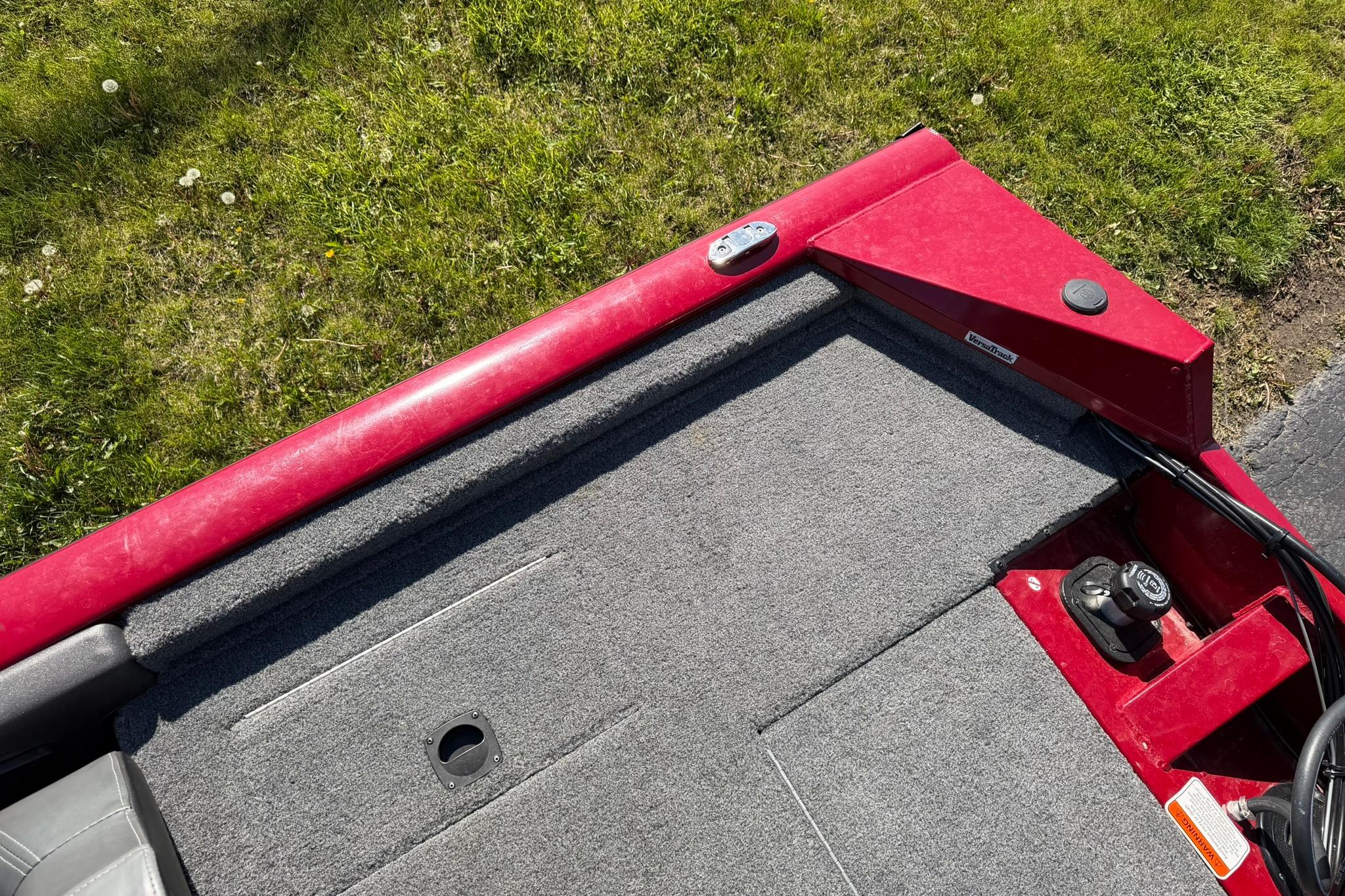 2024 Tracker Pro Team 175 TXW boat deck with red trim and gray carpet.