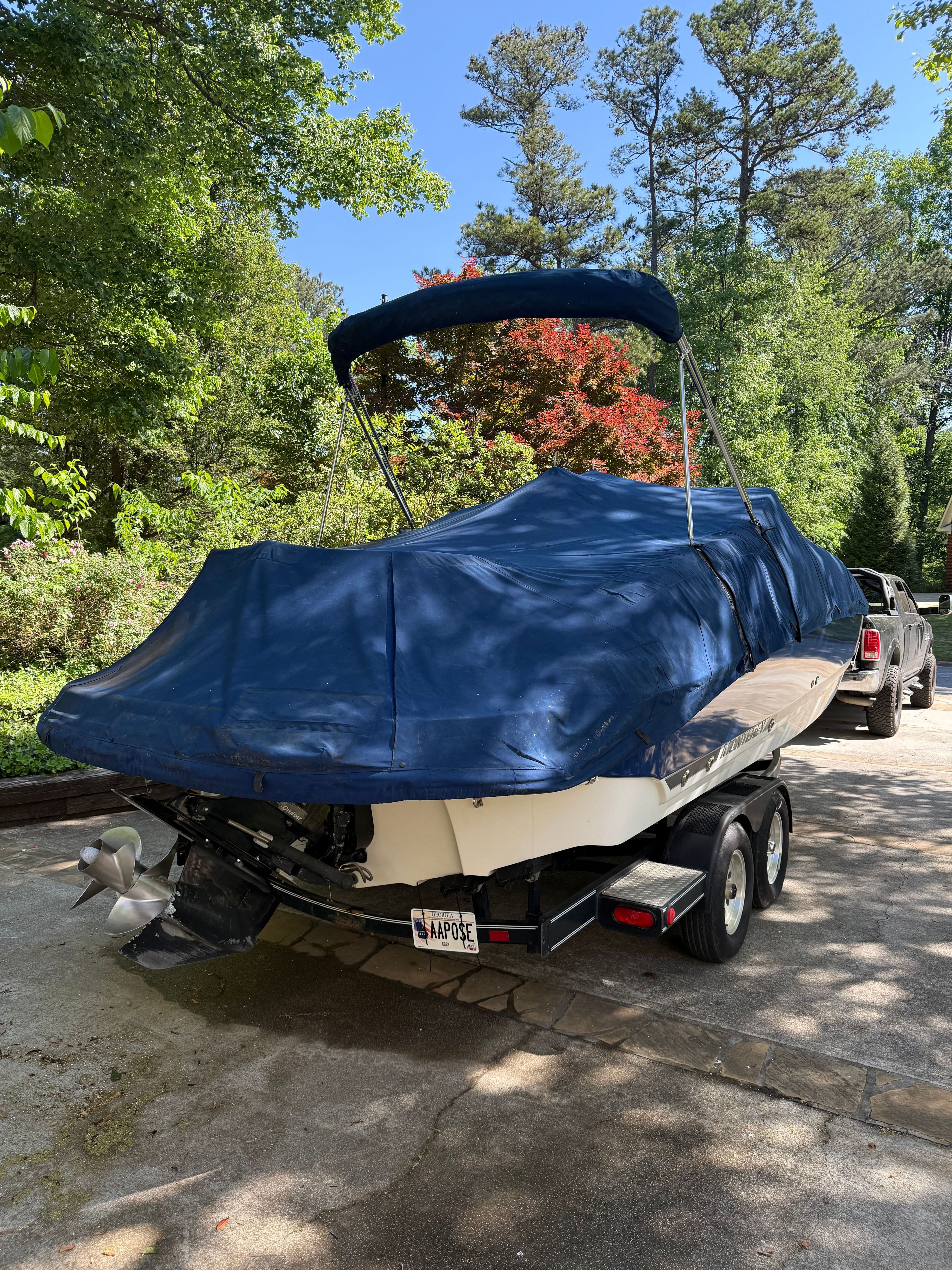 A 2005 Monterey 223 Explorer Sport boat, covered and parked on a trailer.