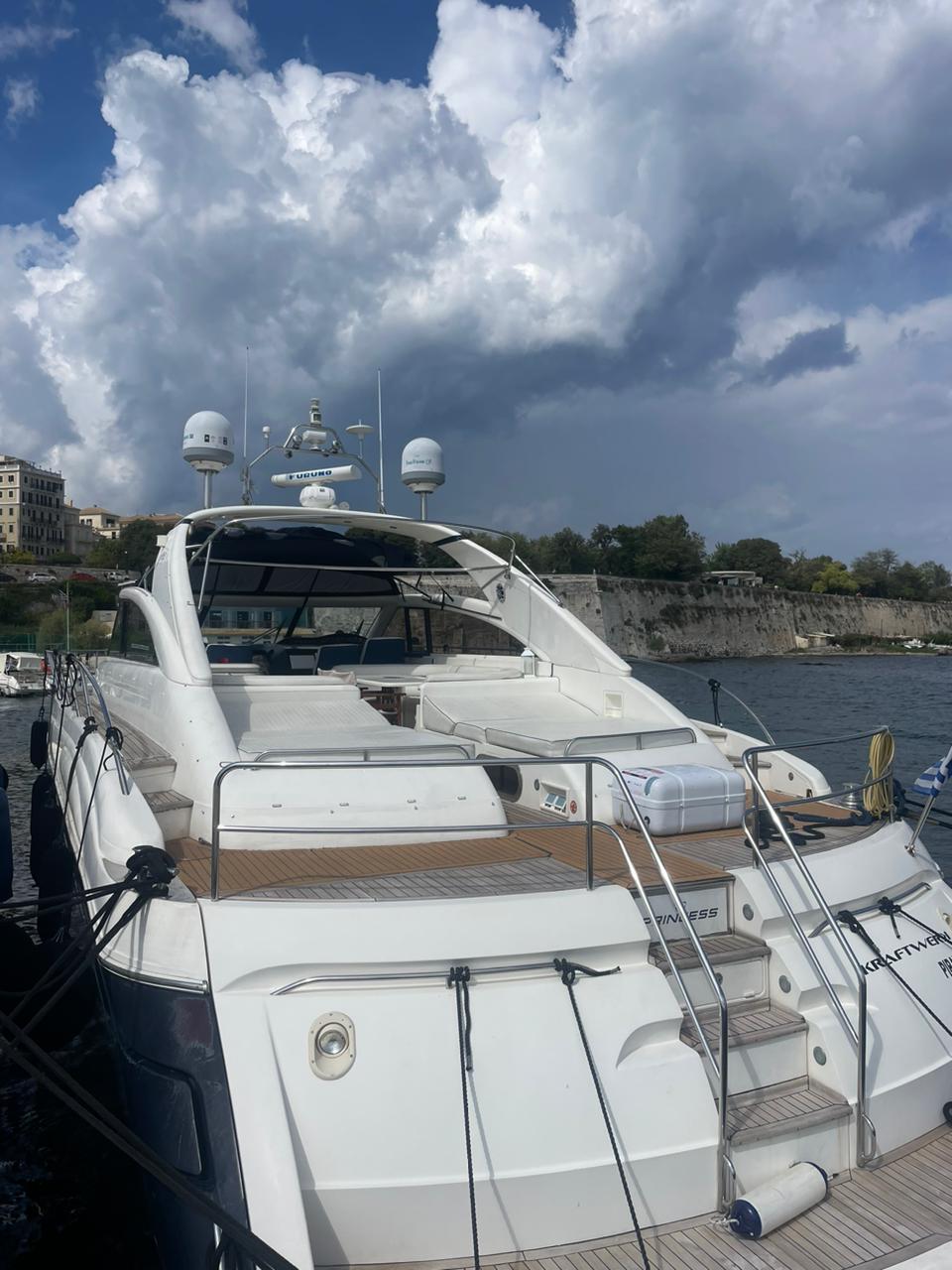 2004 Princess V65 yacht docked under cloudy sky, showcasing luxury design and spacious deck.