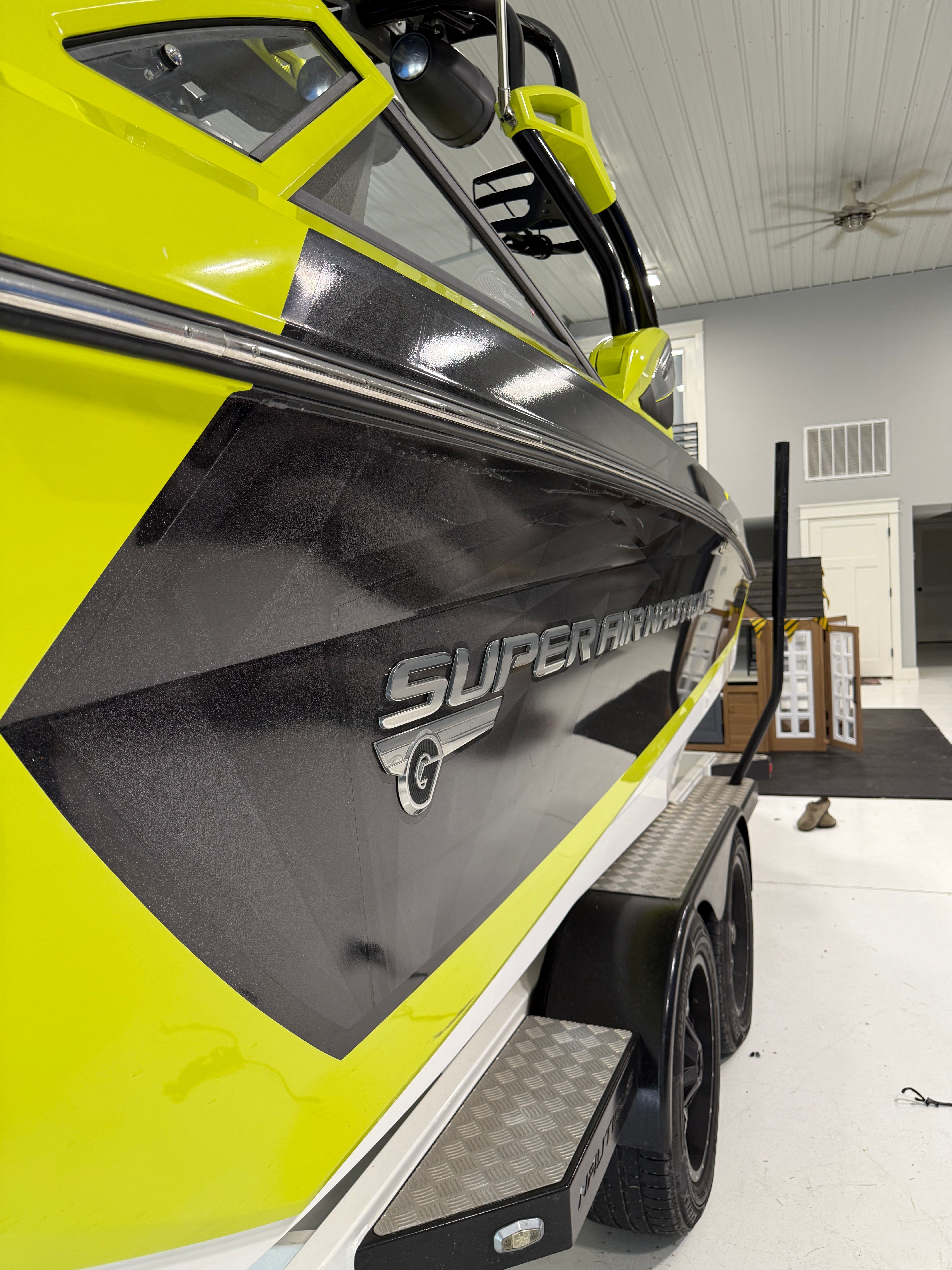 Close-up of a yellow and black boat on a trailer inside a building.
