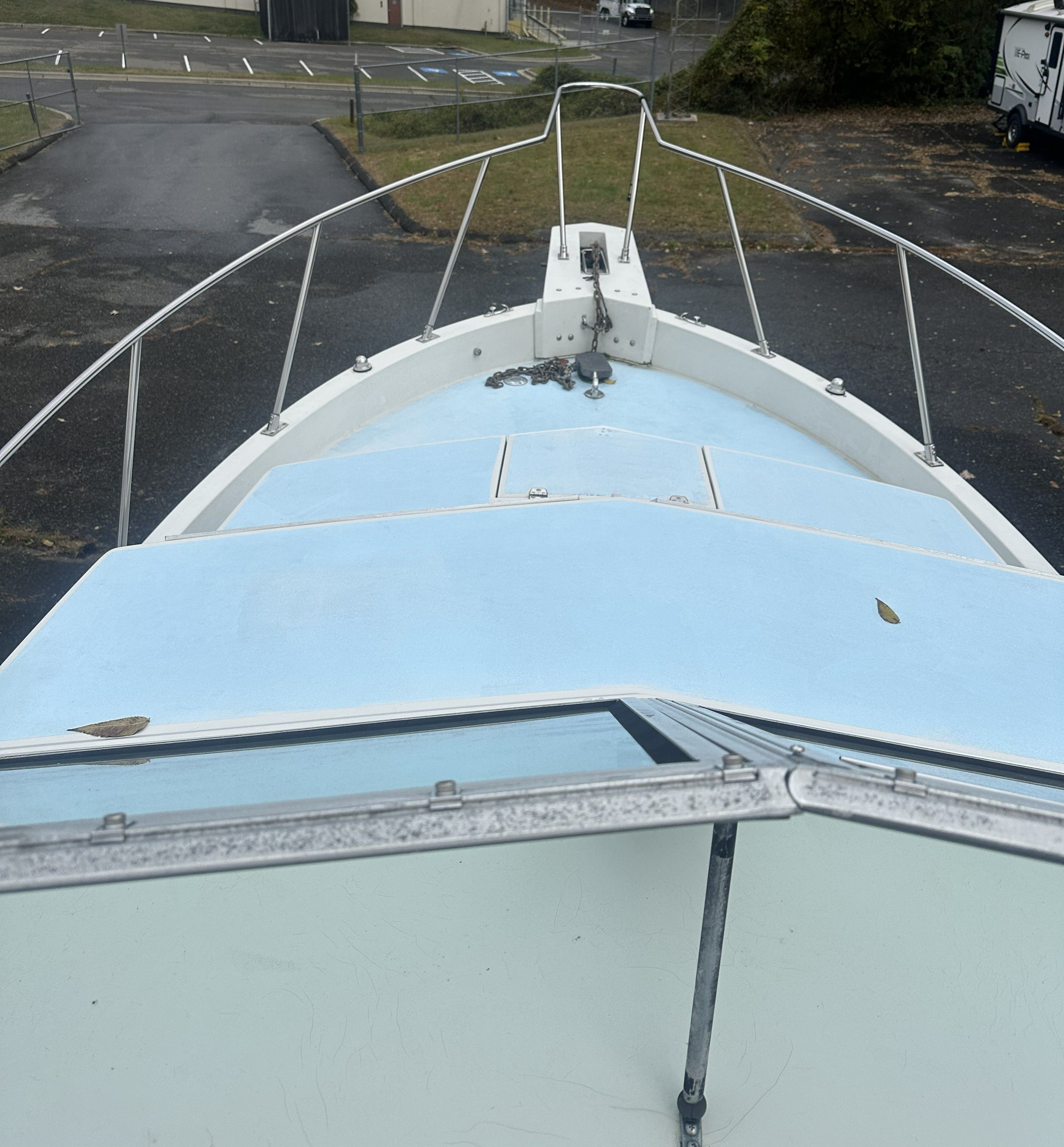 Bow of a 1989 Wellcraft 250 Sportsman, parked in a lot.