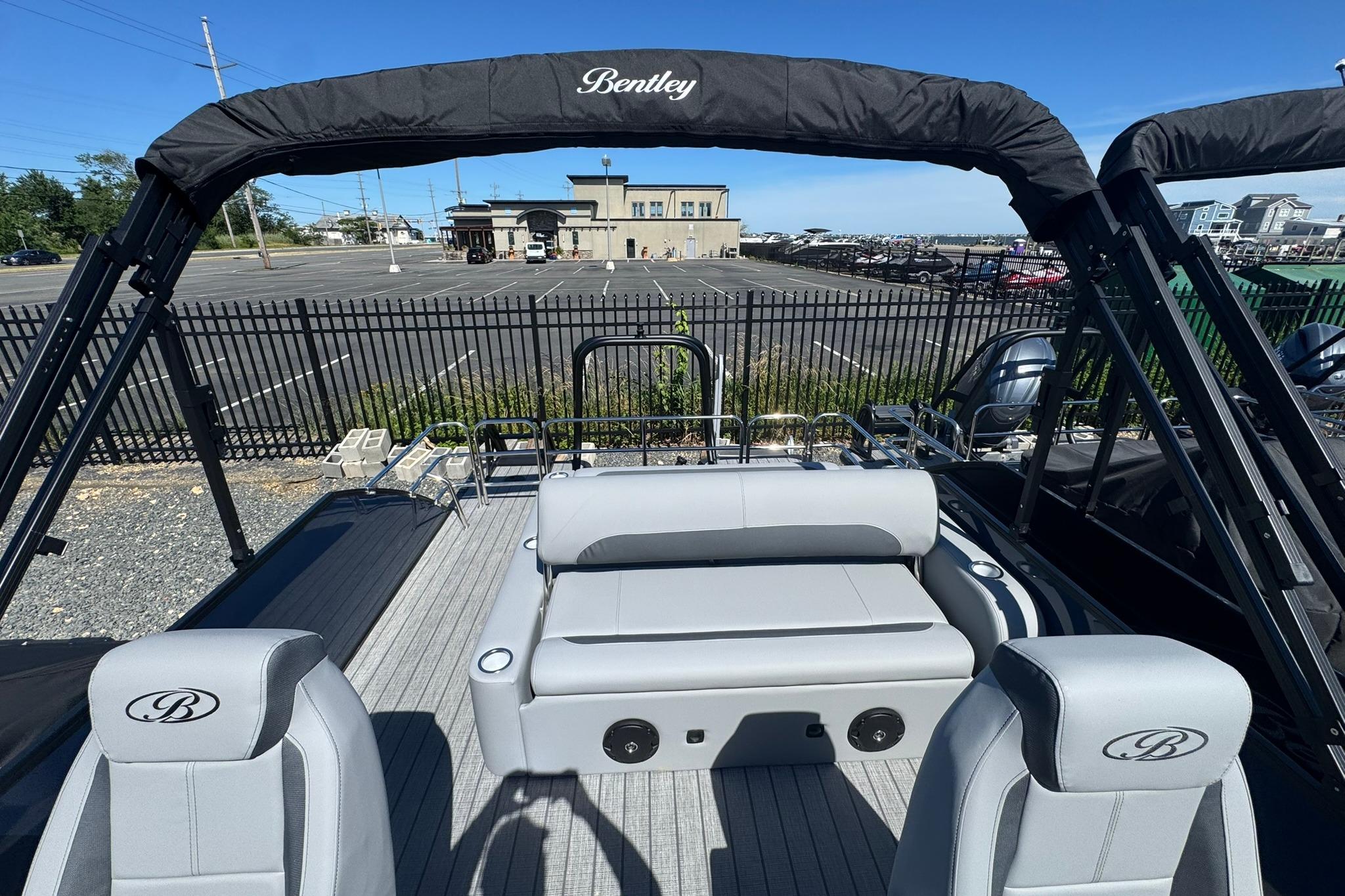 2026 Bentley Pontoons Legacy 243 Swingback with sleek seating and modern design in a marina setting.