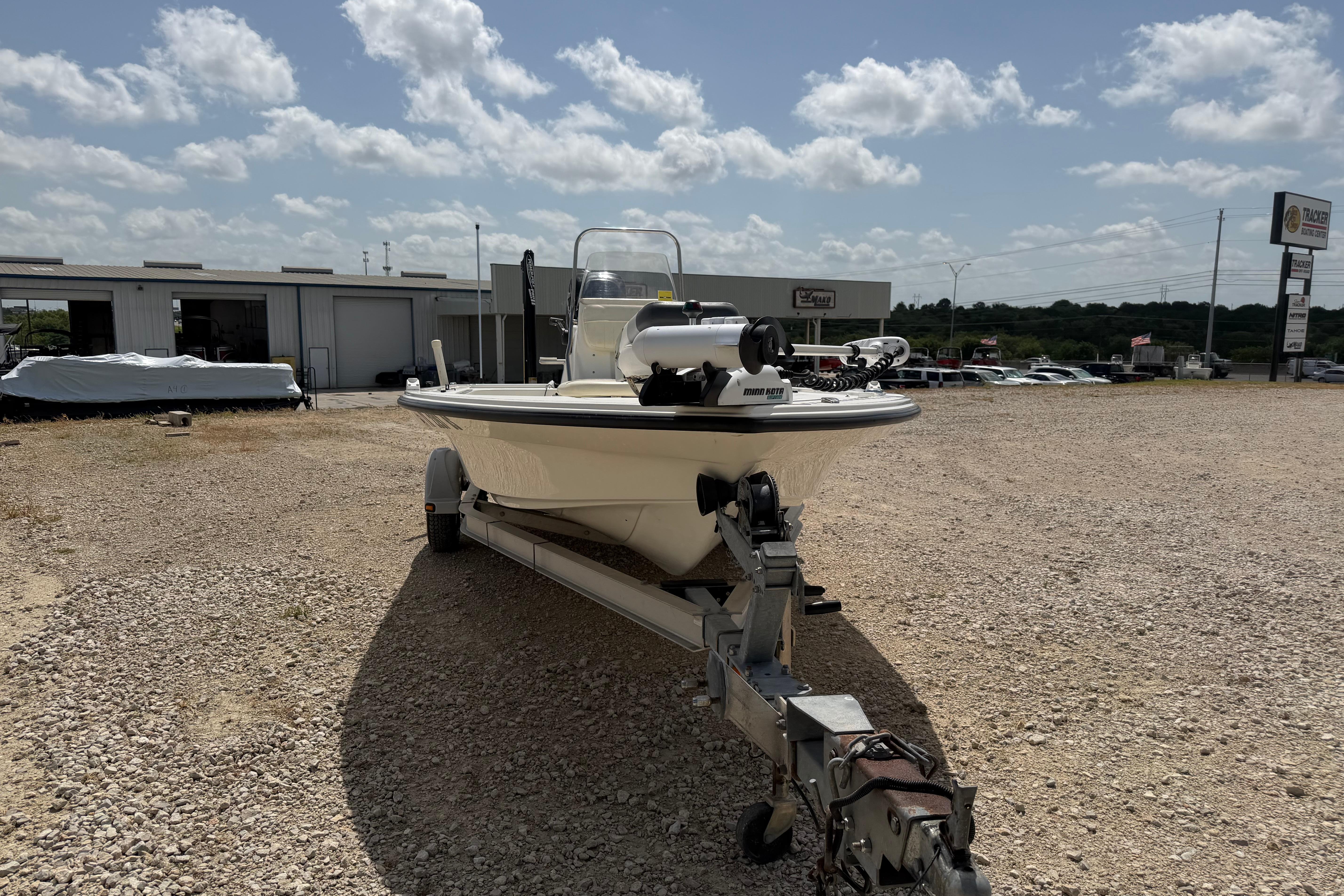 2012 Mako 18 LTS boat on trailer in outdoor dealership lot under cloudy sky.