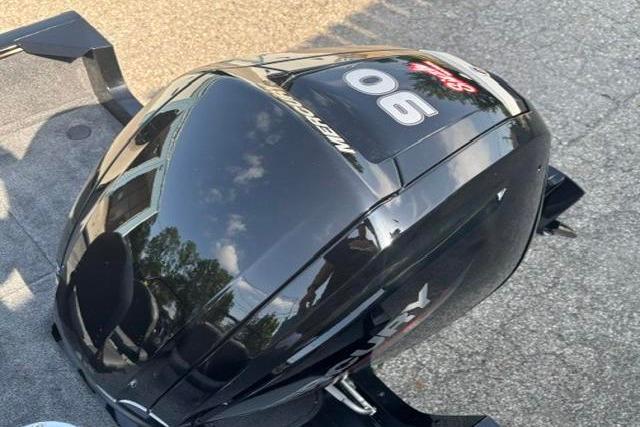 2026 Tracker Pro Guide V-16 WT with Mercury 90 outboard motor, parked on pavement.