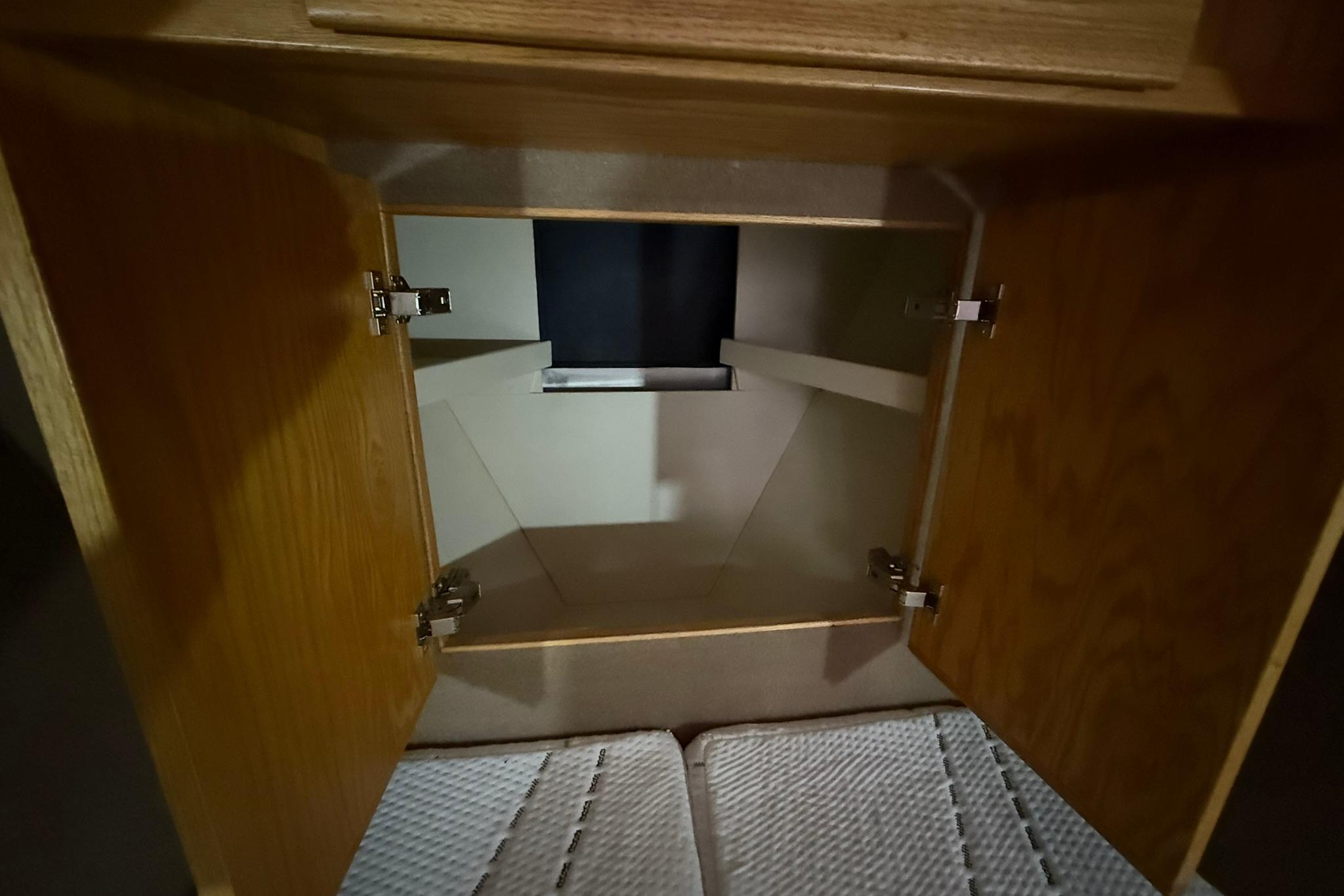 Open wooden cabinet inside 2013 Eco-Trawler 33 boat, showcasing interior storage space.