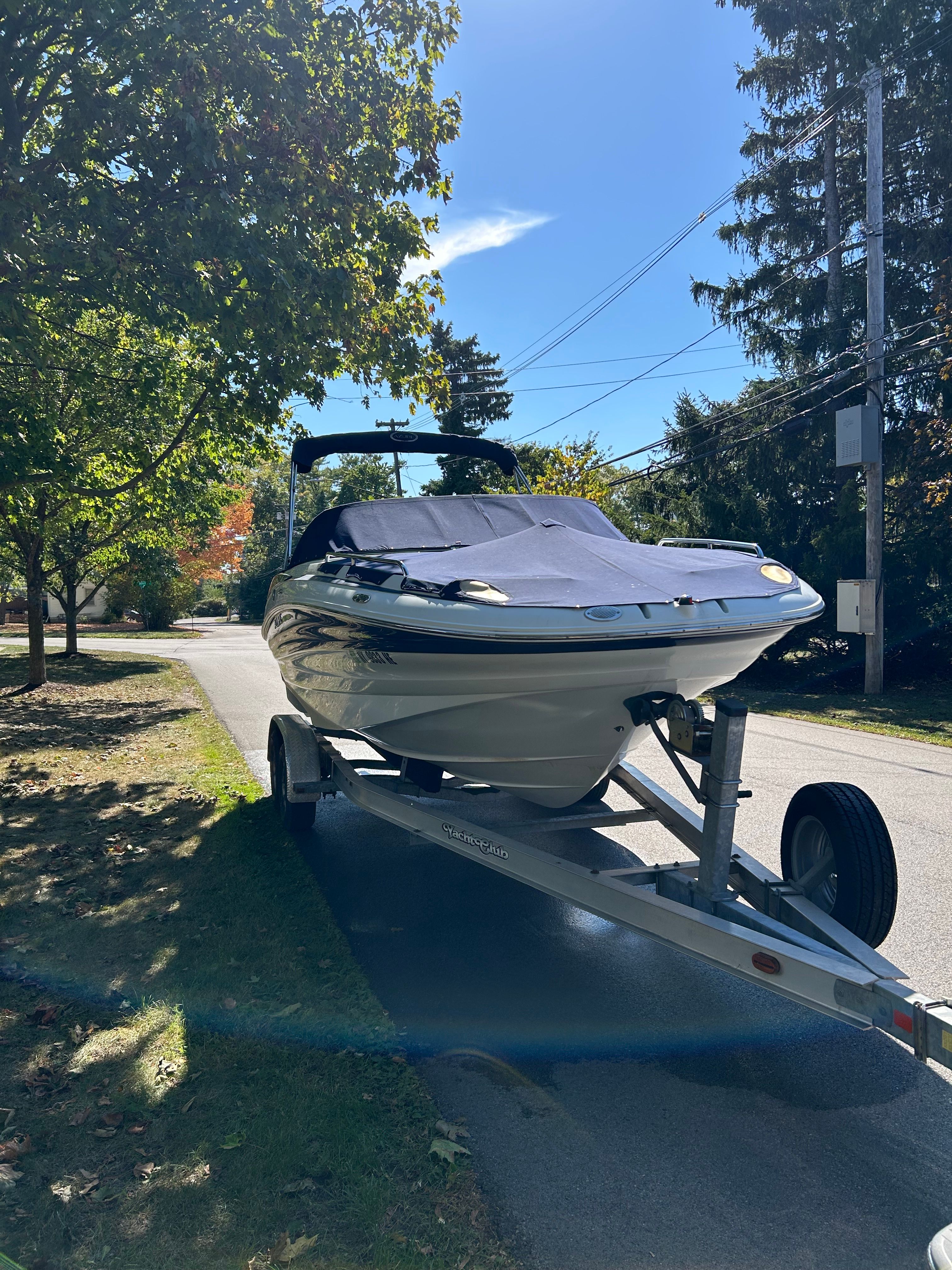 A 2008 Azure AZ220 boat is on a trailer in a quiet street.
