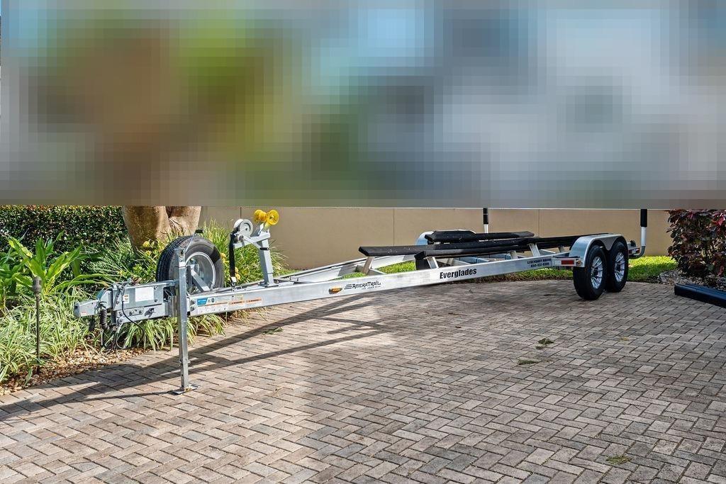 Boat trailer for Everglades 243 Center Console 2023 on paved path.