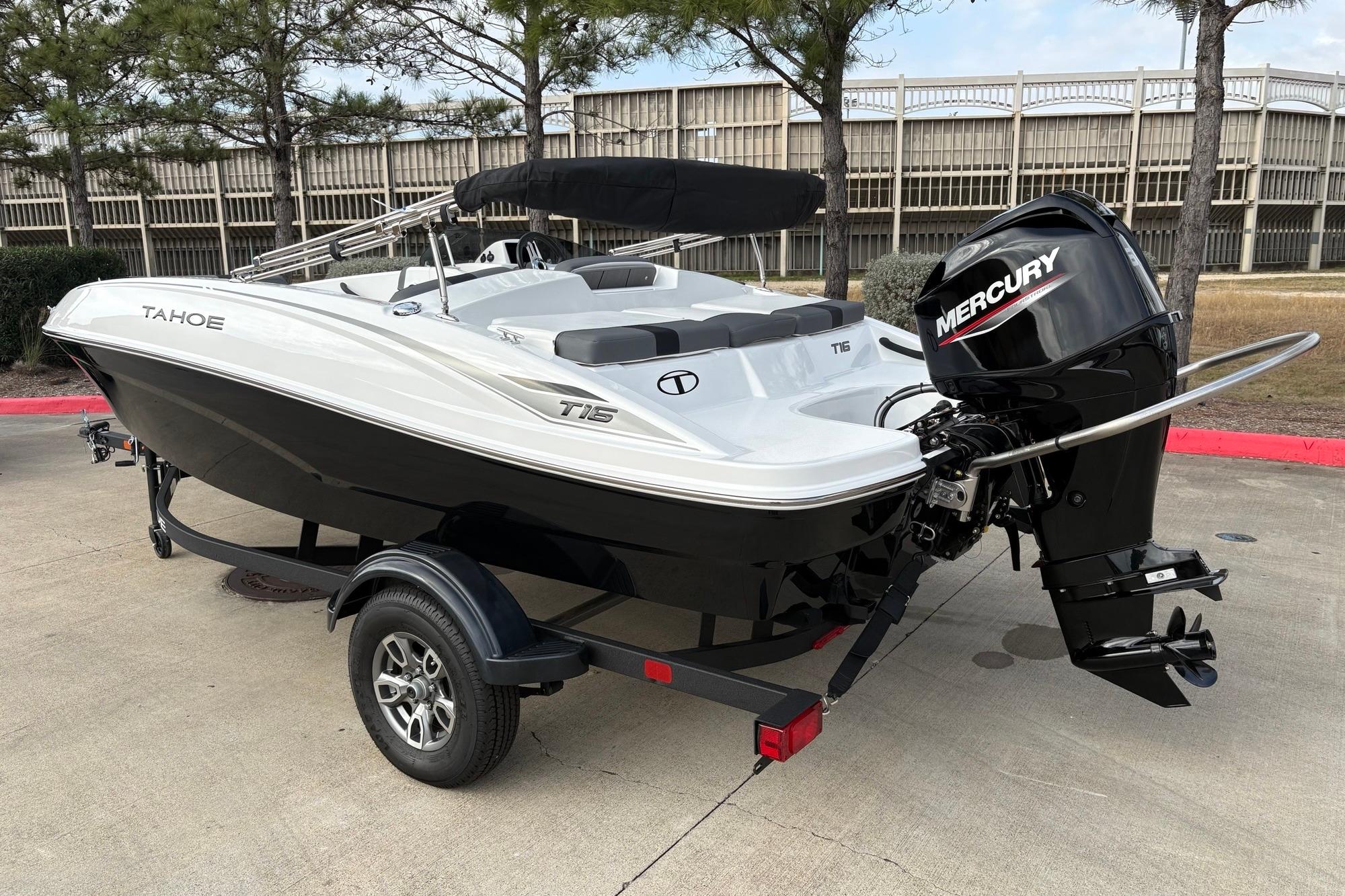 2025 Tahoe T16 boat with Mercury engine on trailer, parked outdoors.
