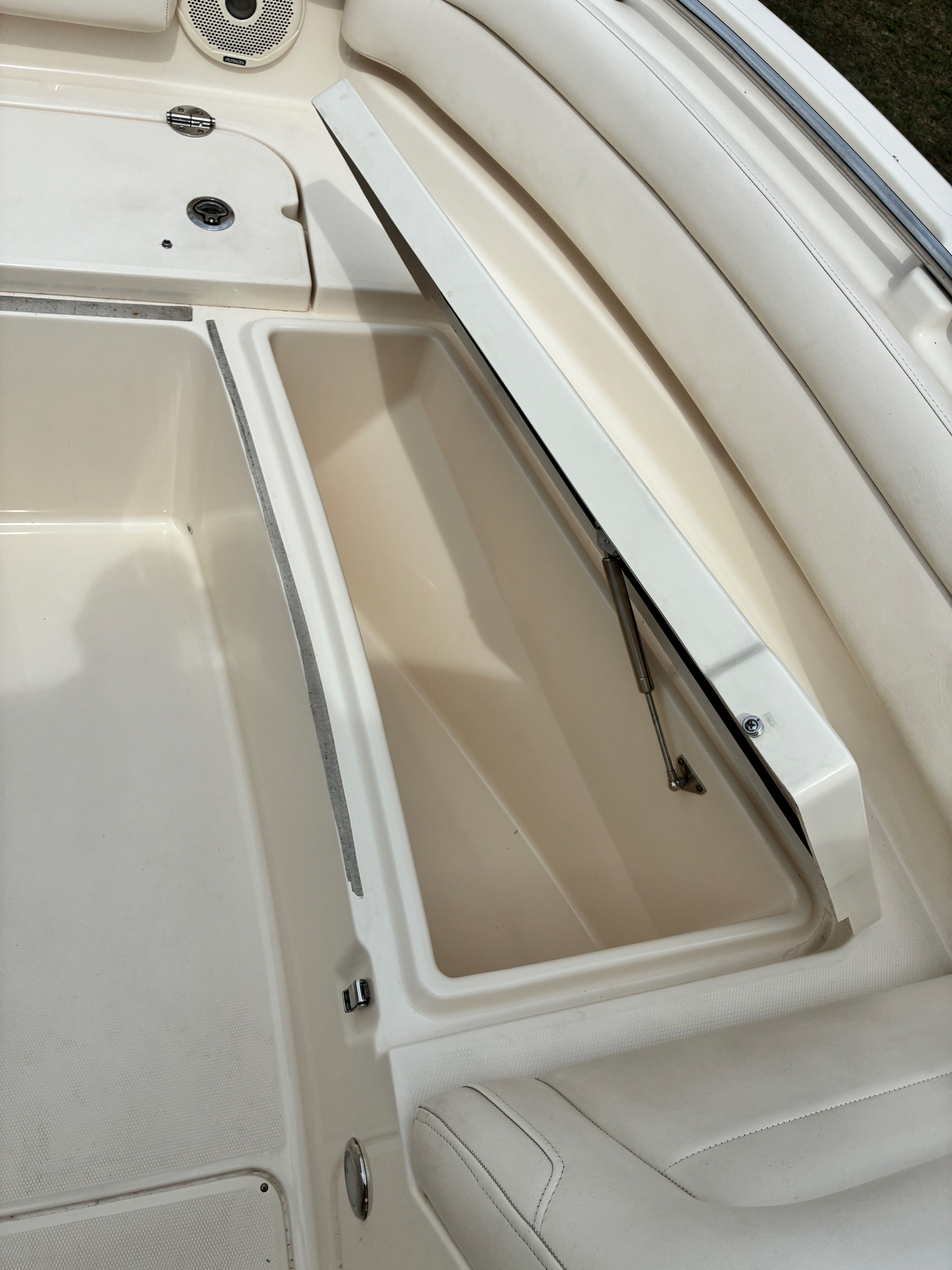 Interior of a 2018 Grady-White Freedom235 boat with open storage compartment.