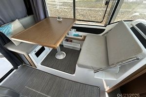 Interior of Jeanneau NC 895, 2021, featuring dining table and seating area.