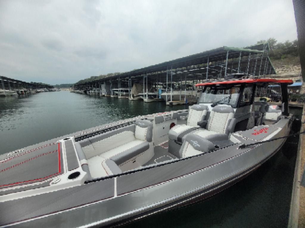 2024 Fountain 38 SCX boat docked at marina, featuring sleek design and spacious seating.