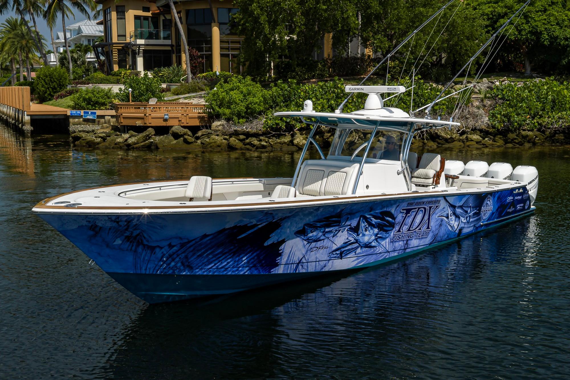 2020 Valhalla Boatworks V-41 with custom graphics, docked near lush greenery.