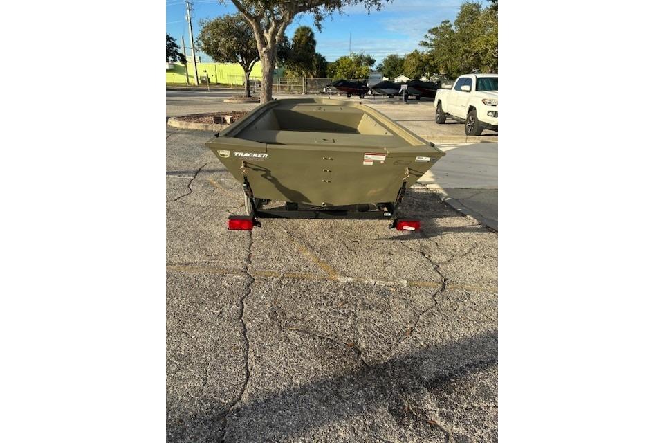 2026 Tracker Grizzly 1648 Utility boat on trailer in parking lot.
