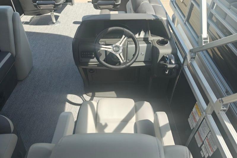 2026 Sun Tracker Fishin' Barge 20 DLX interior with steering wheel and seating.