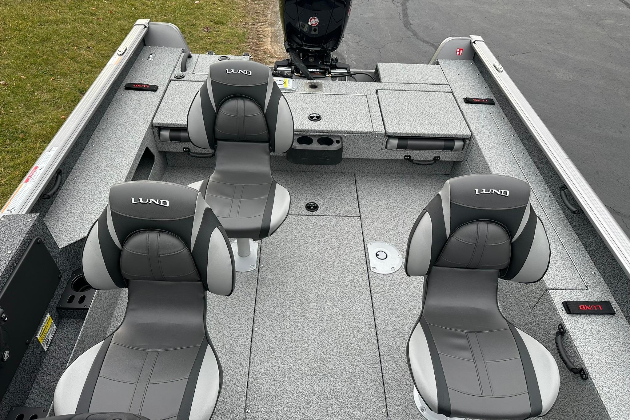 2026 Lund 1875 Impact XS SS boat interior with four gray seats and storage compartments.