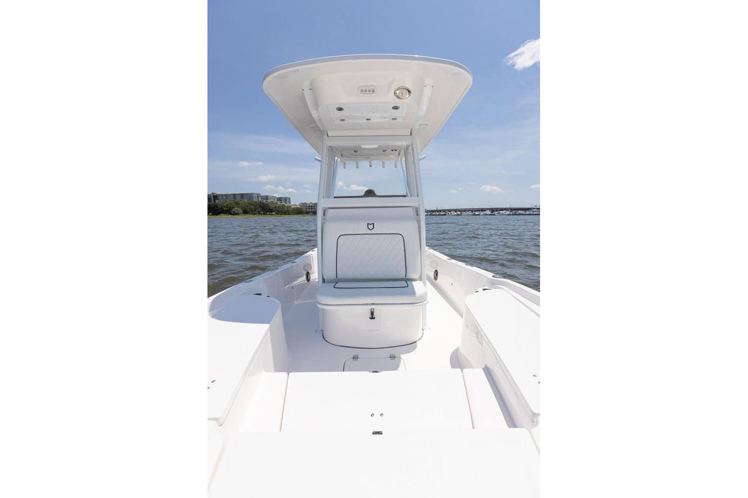 2027 Sea Fox 231 Bay Fox boat on water, featuring spacious deck and seating.