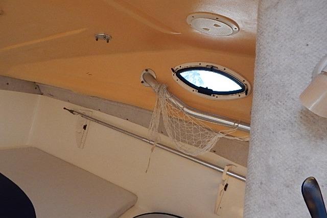 Interior view of a 2003 World Cat 270 EC boat cabin with porthole and storage net.