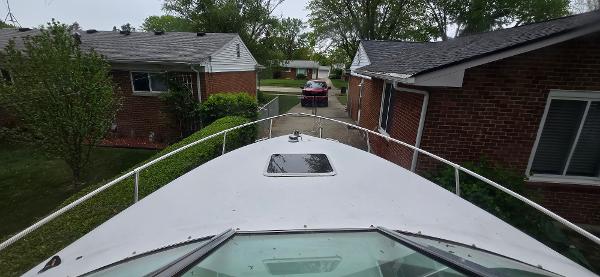 Bow view of a 1999 Sea Ray 280 SS boat between brick houses.