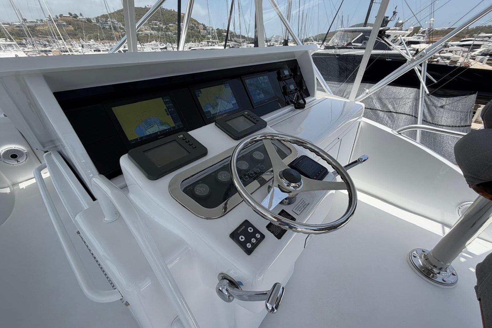 Helm of 2003 Hatteras 54 Convertible yacht with navigation displays and steering wheel.