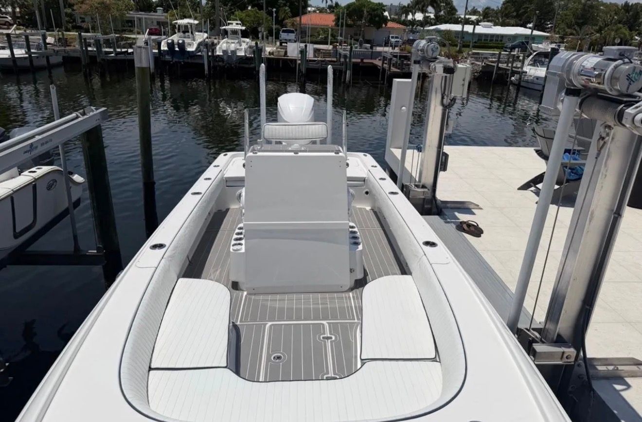 The image shows a 2016 Contender 25 Bay boat docked at a marina.