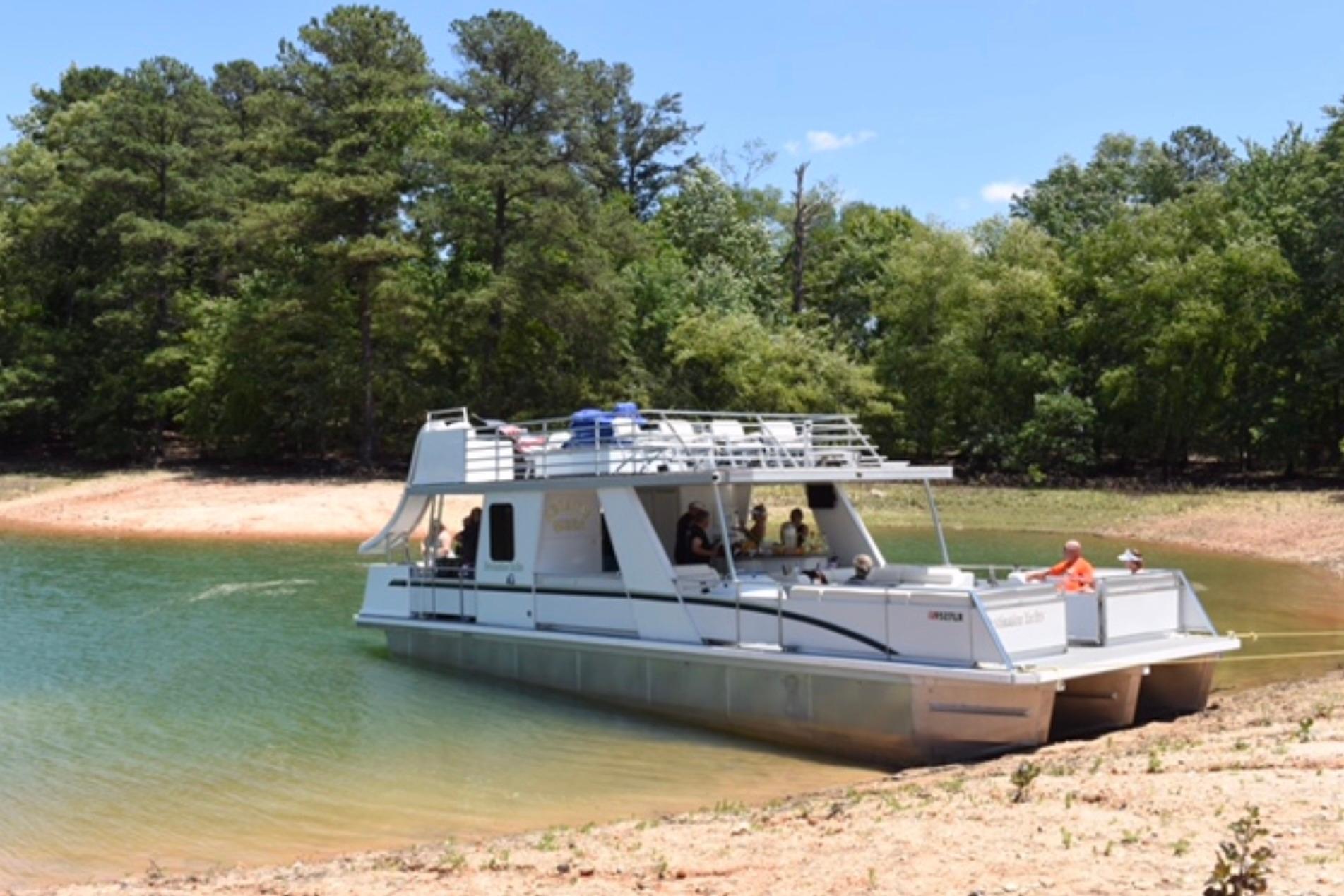 2008 Destination Yachts 45X14 houseboat on a serene lake with lush trees.