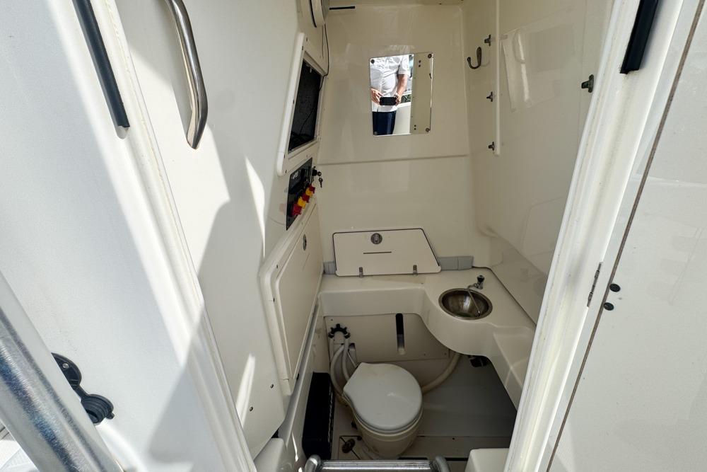 Interior of 2018 Mako 284 Center Console boat with compact bathroom amenities.