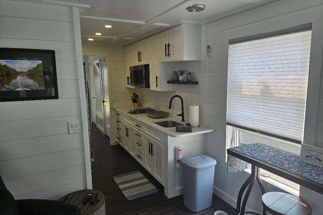 Modern kitchen interior of 2021 East Coast Houseboats Freedom 40, featuring sleek cabinetry and appliances.