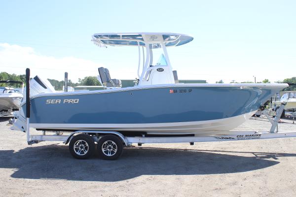2023 Sea Pro 239 Center Console boat on trailer, side view, blue hull.