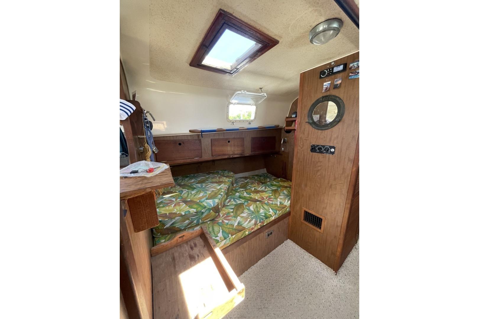 Interior of a 1972 Morgan 40 Ketch sailboat with cozy cabin and floral bedding.
