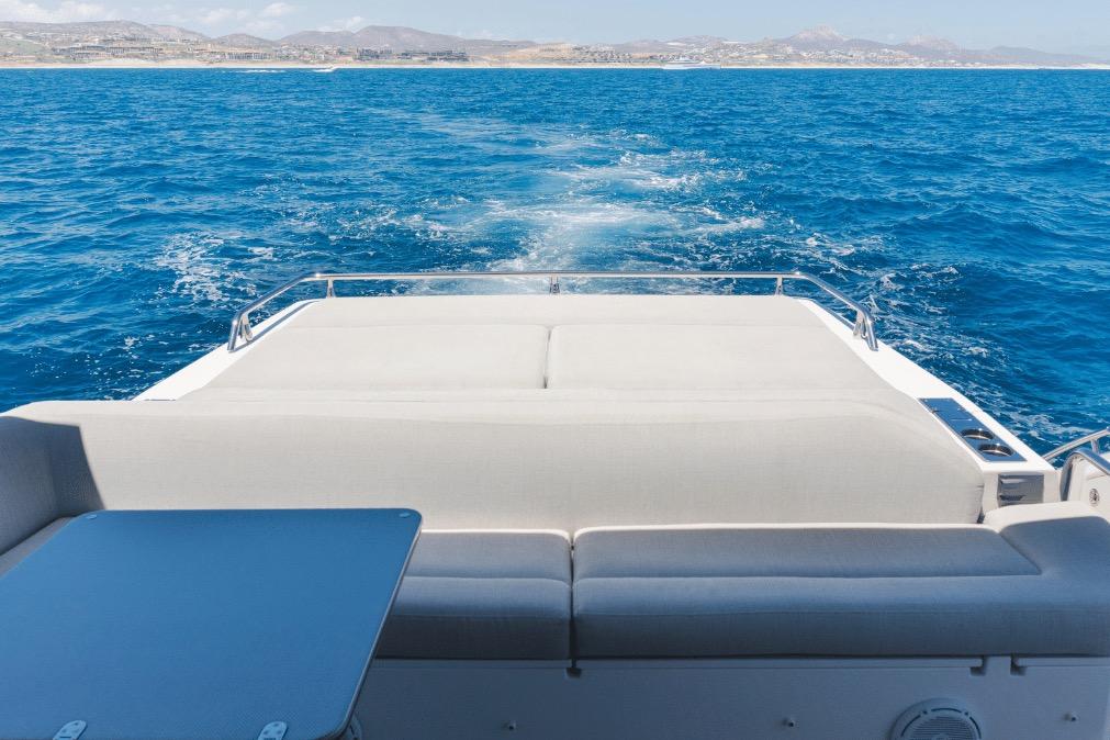 Rear view of 2020 Azimut 60 yacht cruising on open blue sea.