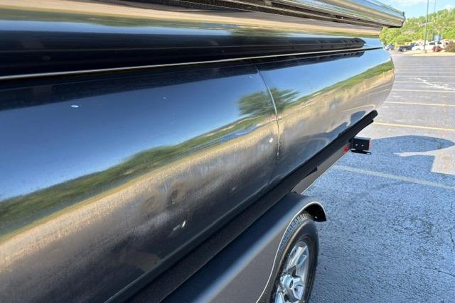 2025 Regency 250 DL3 pontoon boat on trailer, close-up side view in parking lot.
