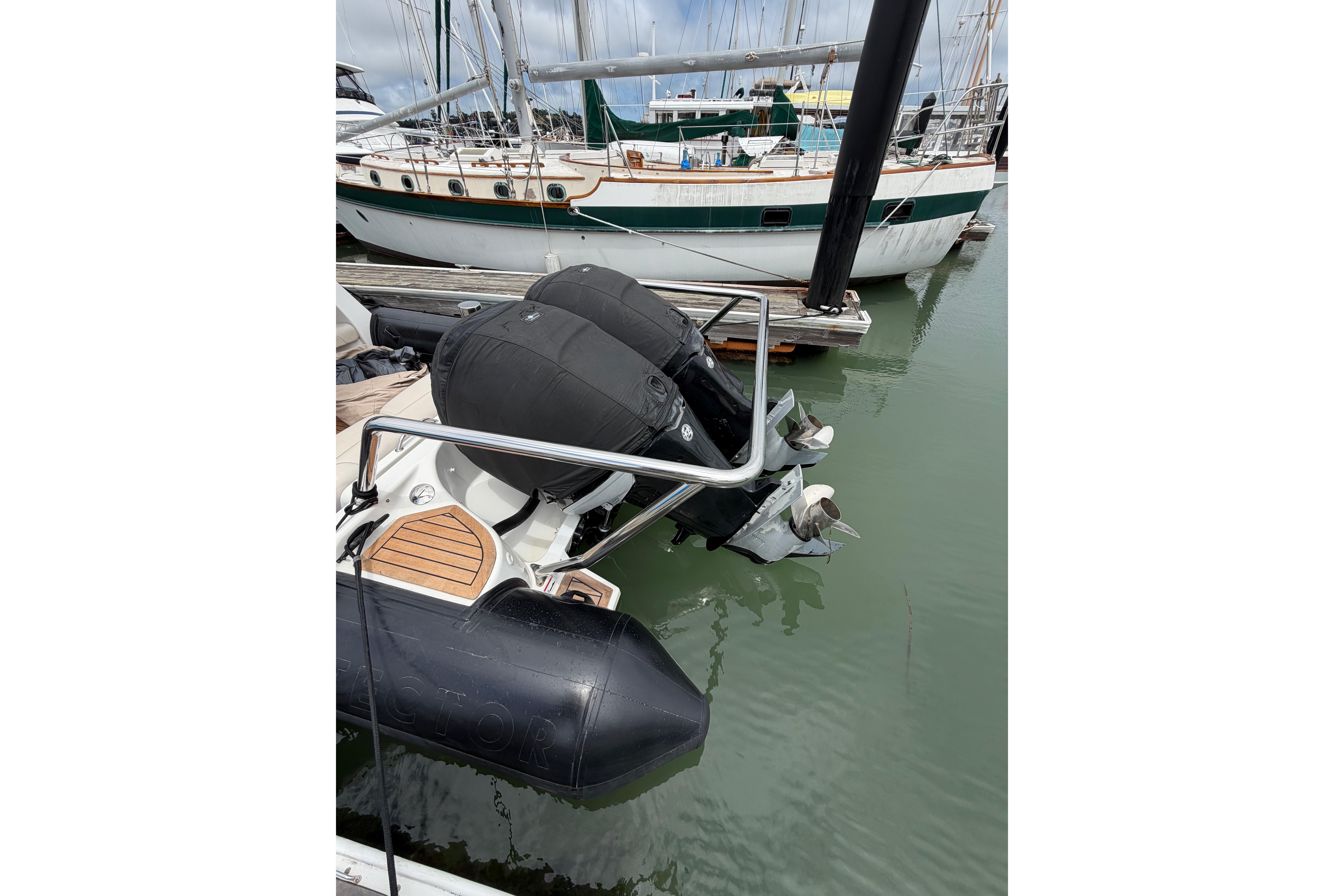 2016 Protector Targa 30 boat with dual outboard motors docked in marina.