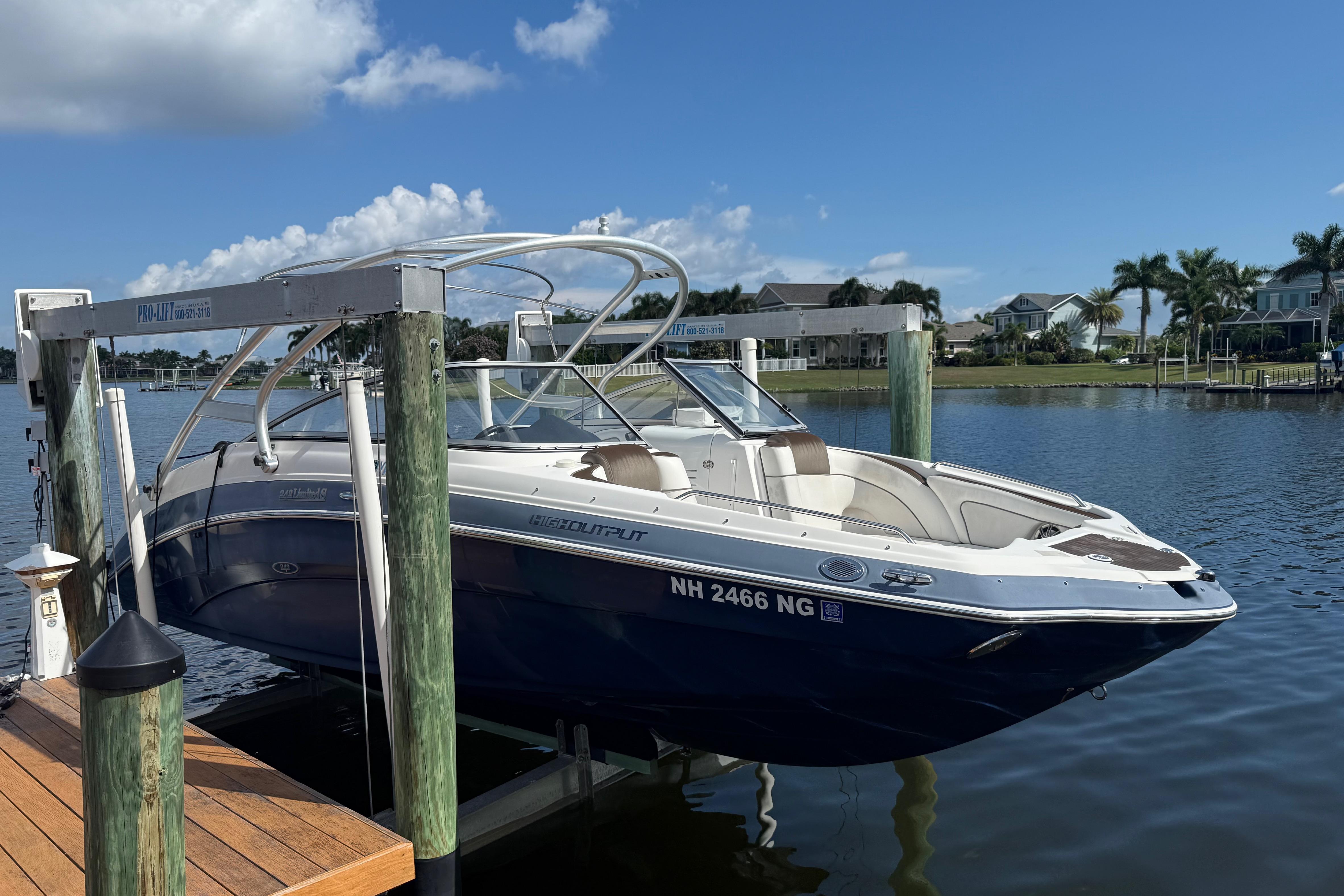 2014 Yamaha Boats 242 Limited S on lift, docked by waterfront homes.