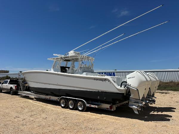 2022 Freeman 42LR boat on trailer with triple outboard engines, parked outdoors.