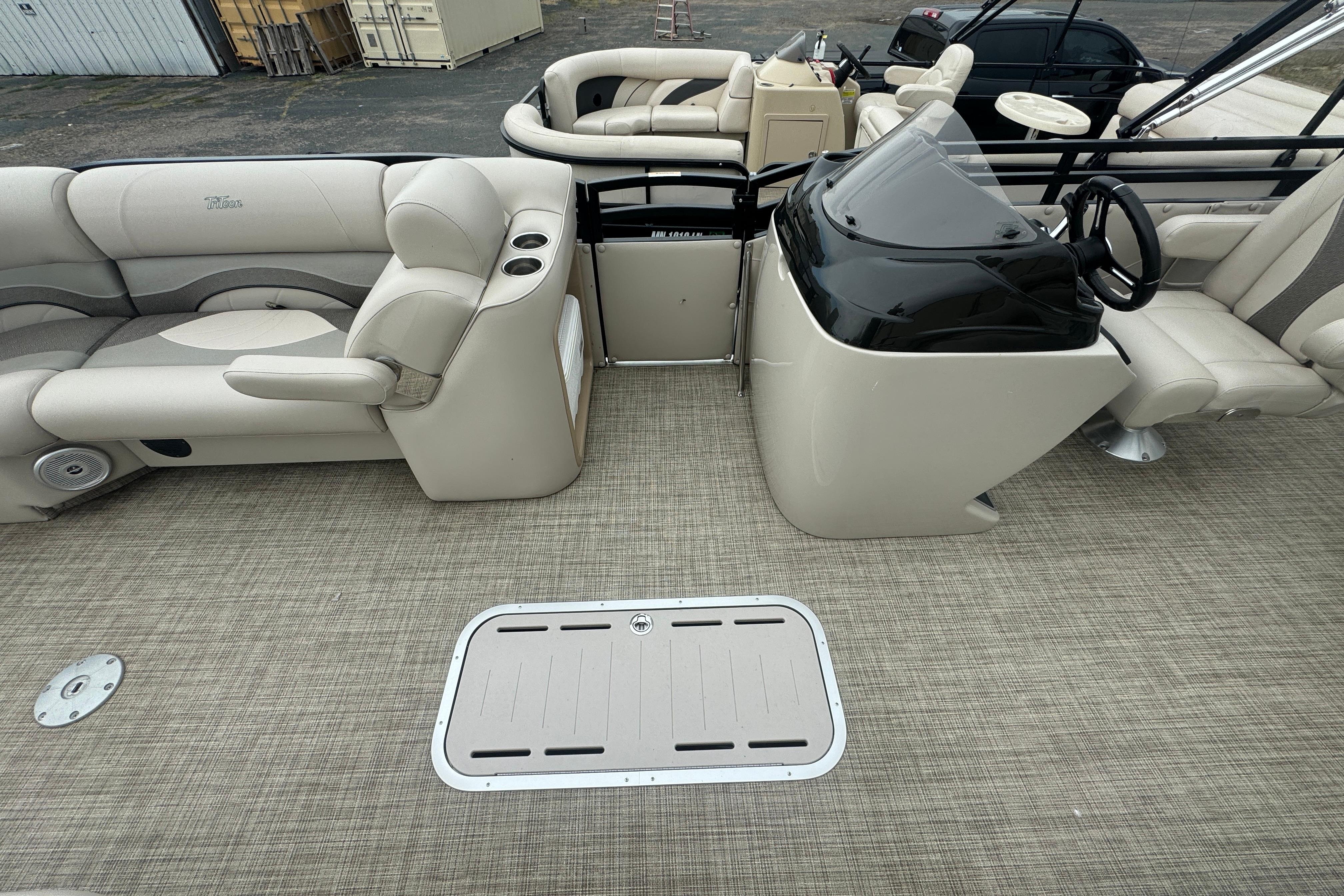 2017 JC 23 Neptoon TT Sport pontoon boat interior with beige seating and helm.