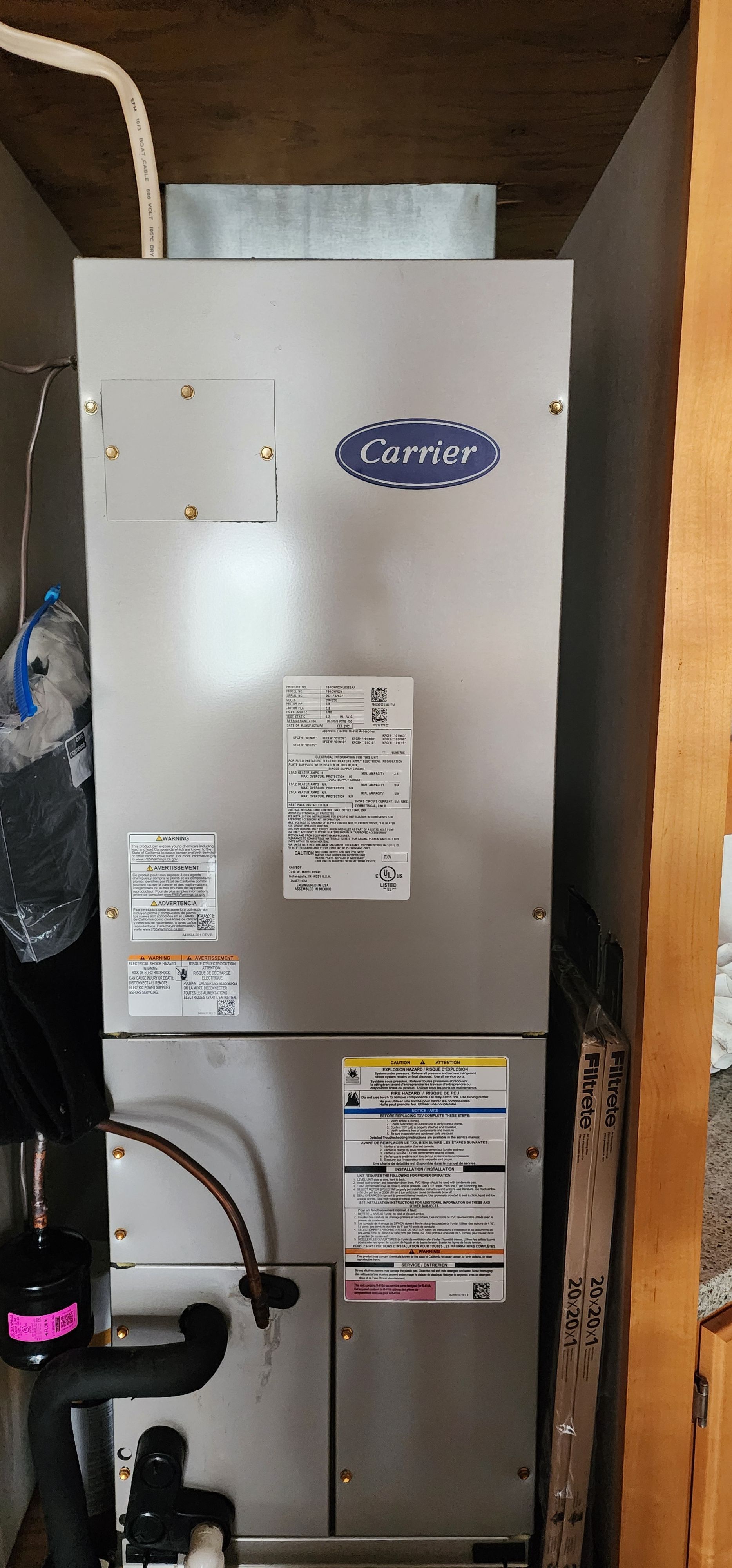 A Carrier HVAC unit installed in a cabinet.