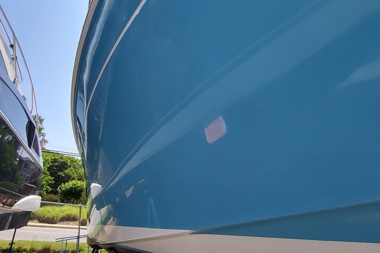 2006 Back Cove 29 boat hull in vibrant blue, docked outdoors.
