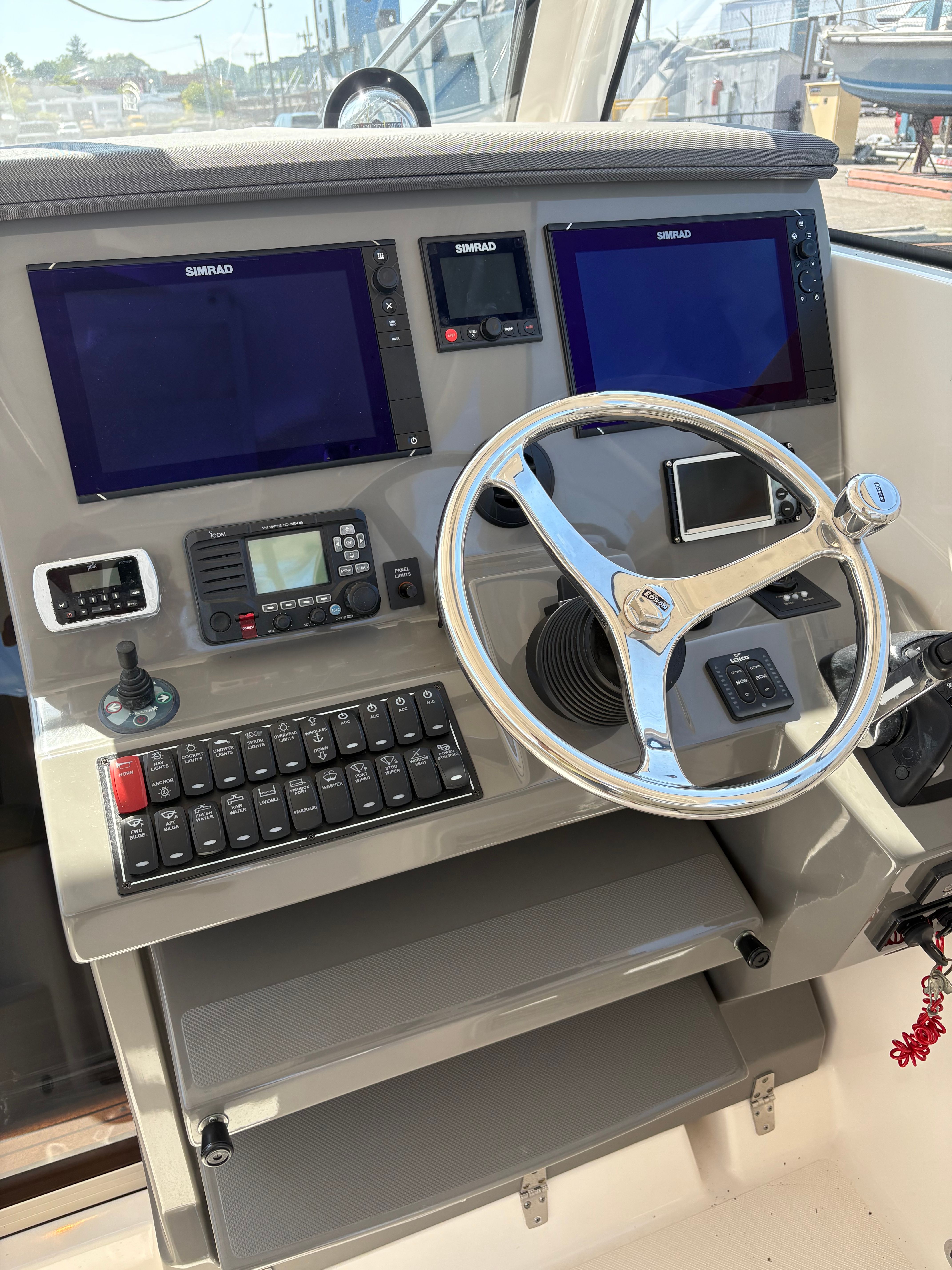 Control panel of 2017 Pursuit OS 355 Offshore boat with steering wheel and navigation screens.