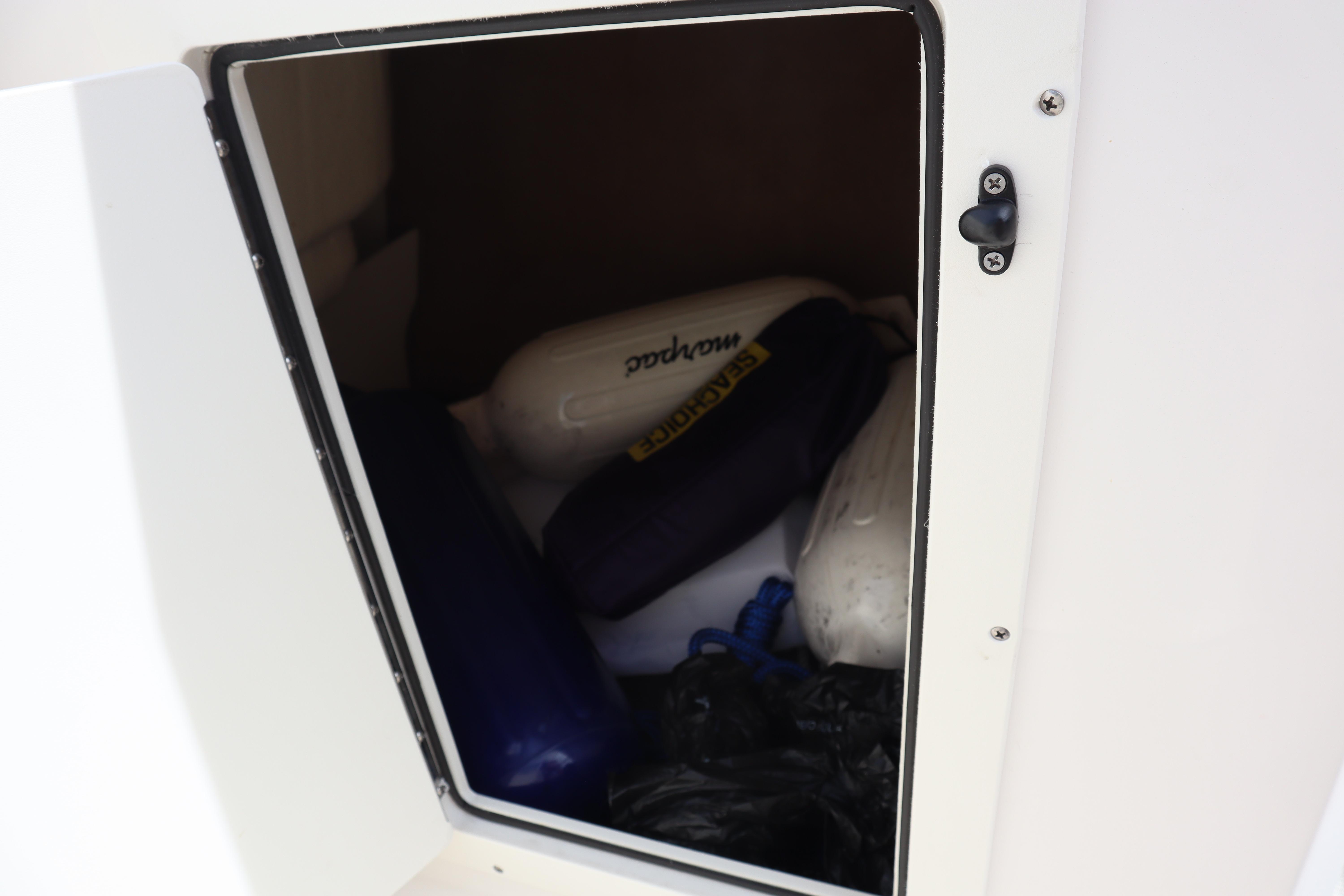 Storage compartment in 2021 Chaparral 21 SSi boat with fenders and equipment.