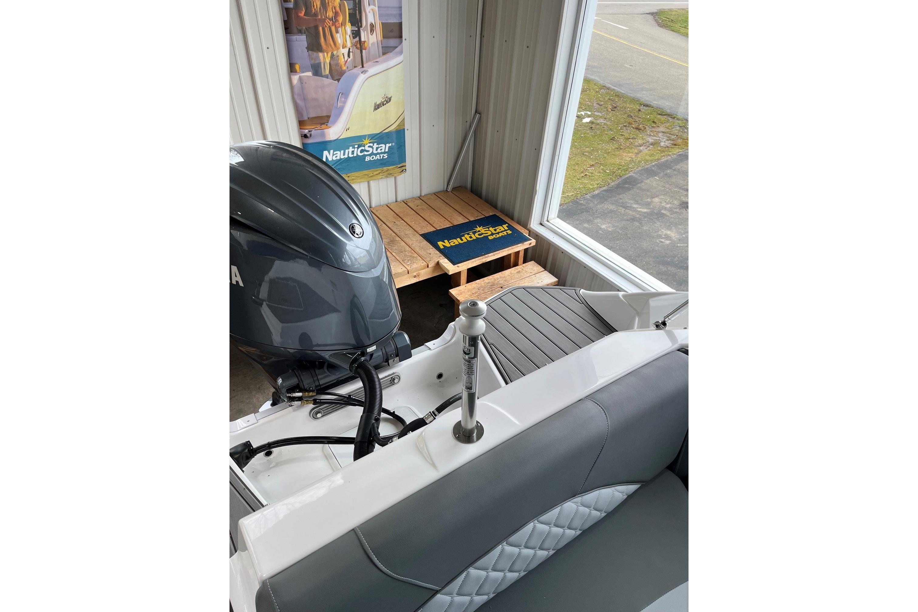 2025 NauticStar 223 DC Deck boat interior with Yamaha engine in showroom.