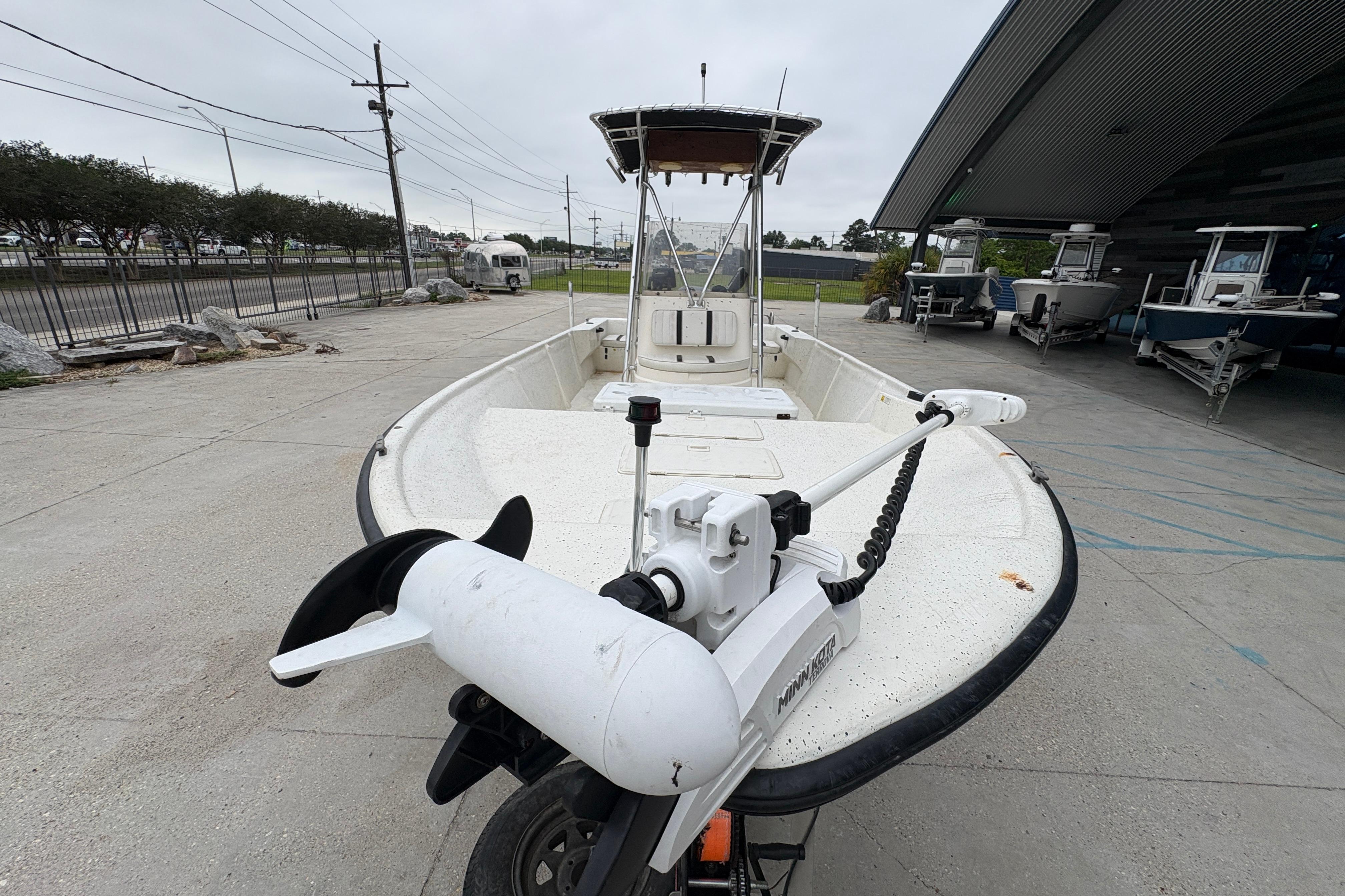 1998 Hydra-Sports 22 Ocean CC boat with trolling motor, parked outdoors.