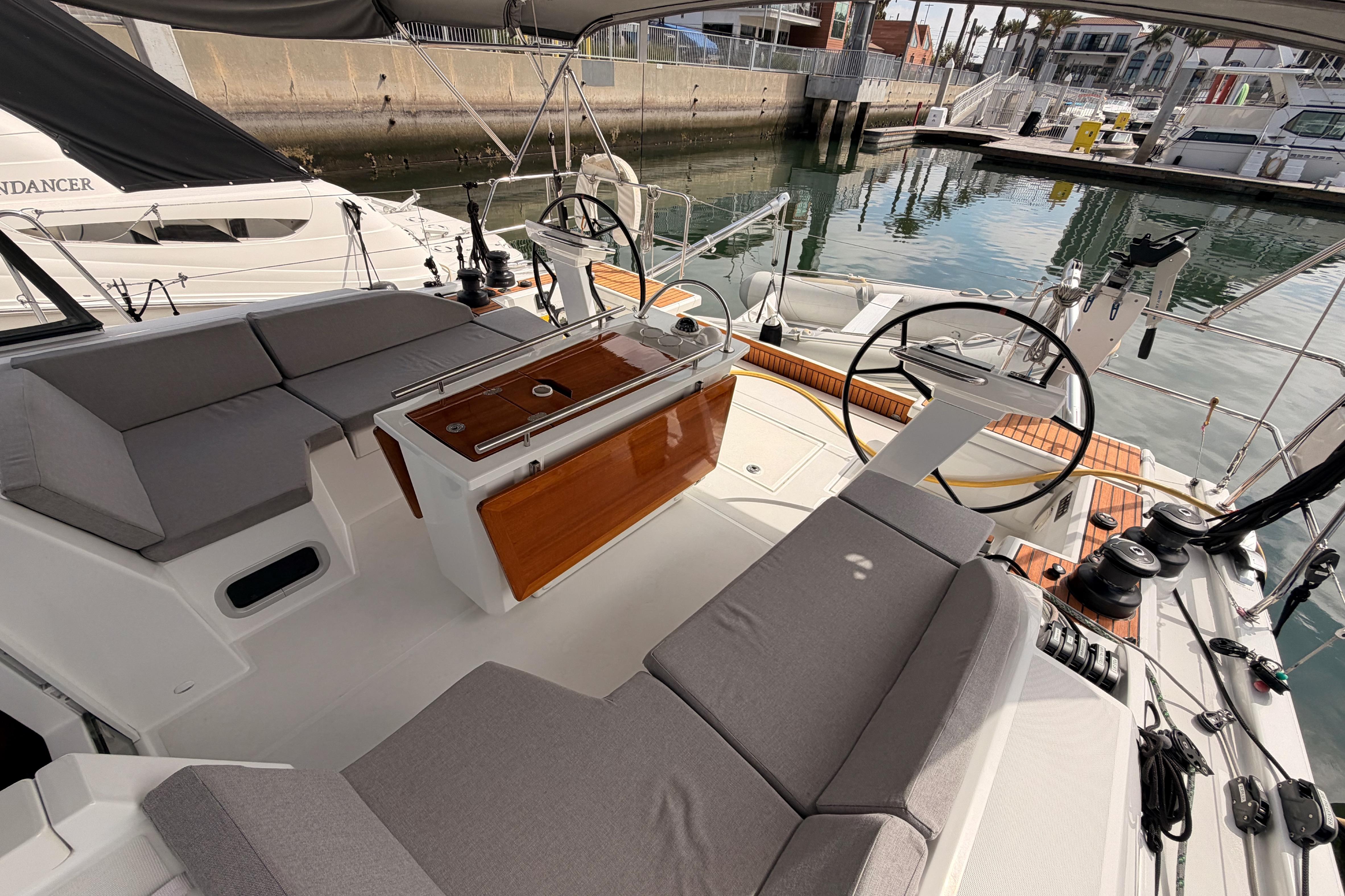 2020 Beneteau Oceanis 46.1 yacht cockpit with seating and steering wheel in marina.