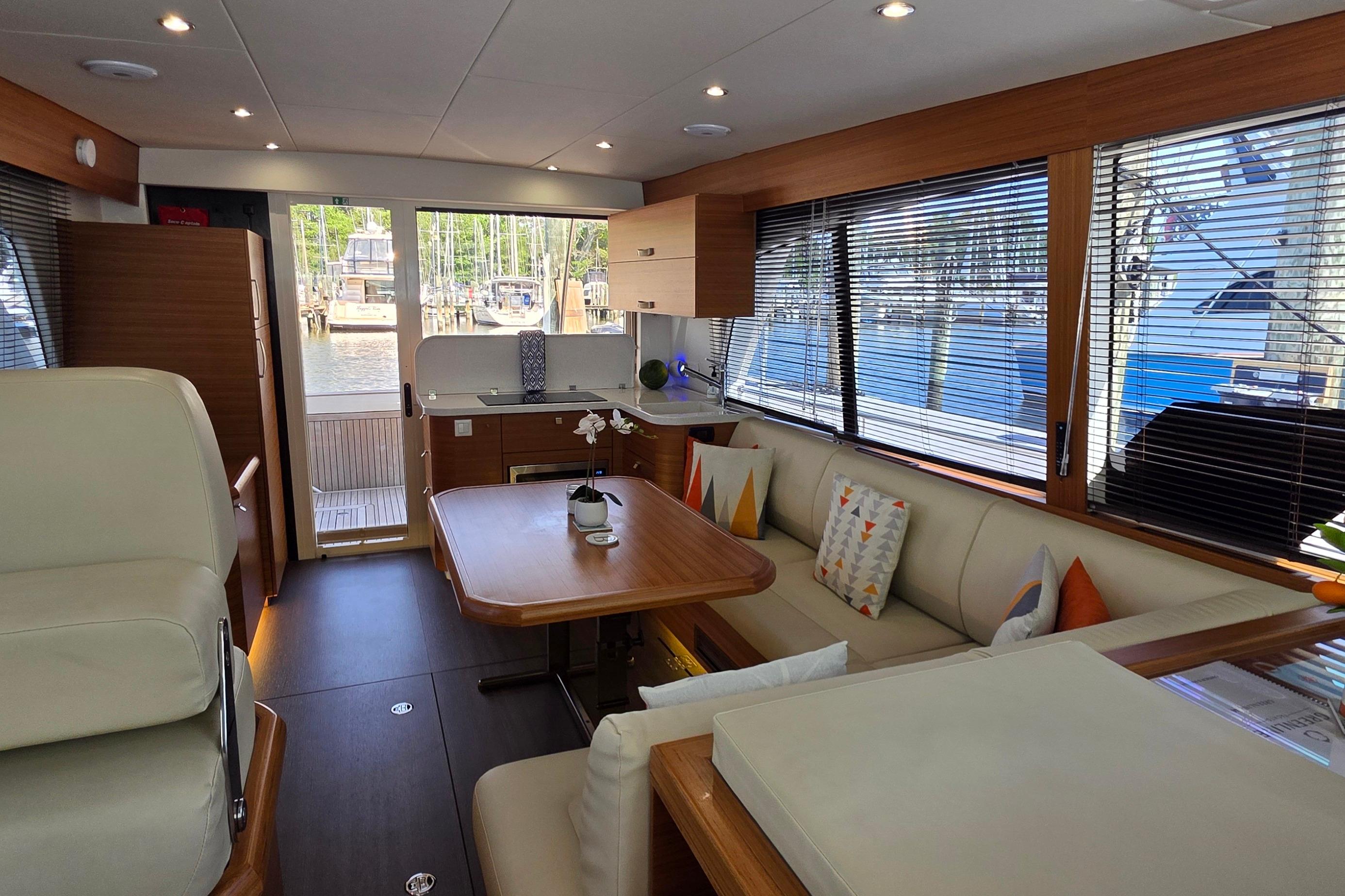 Luxurious interior of 2023 Greenline 40 yacht with modern furnishings and large windows.