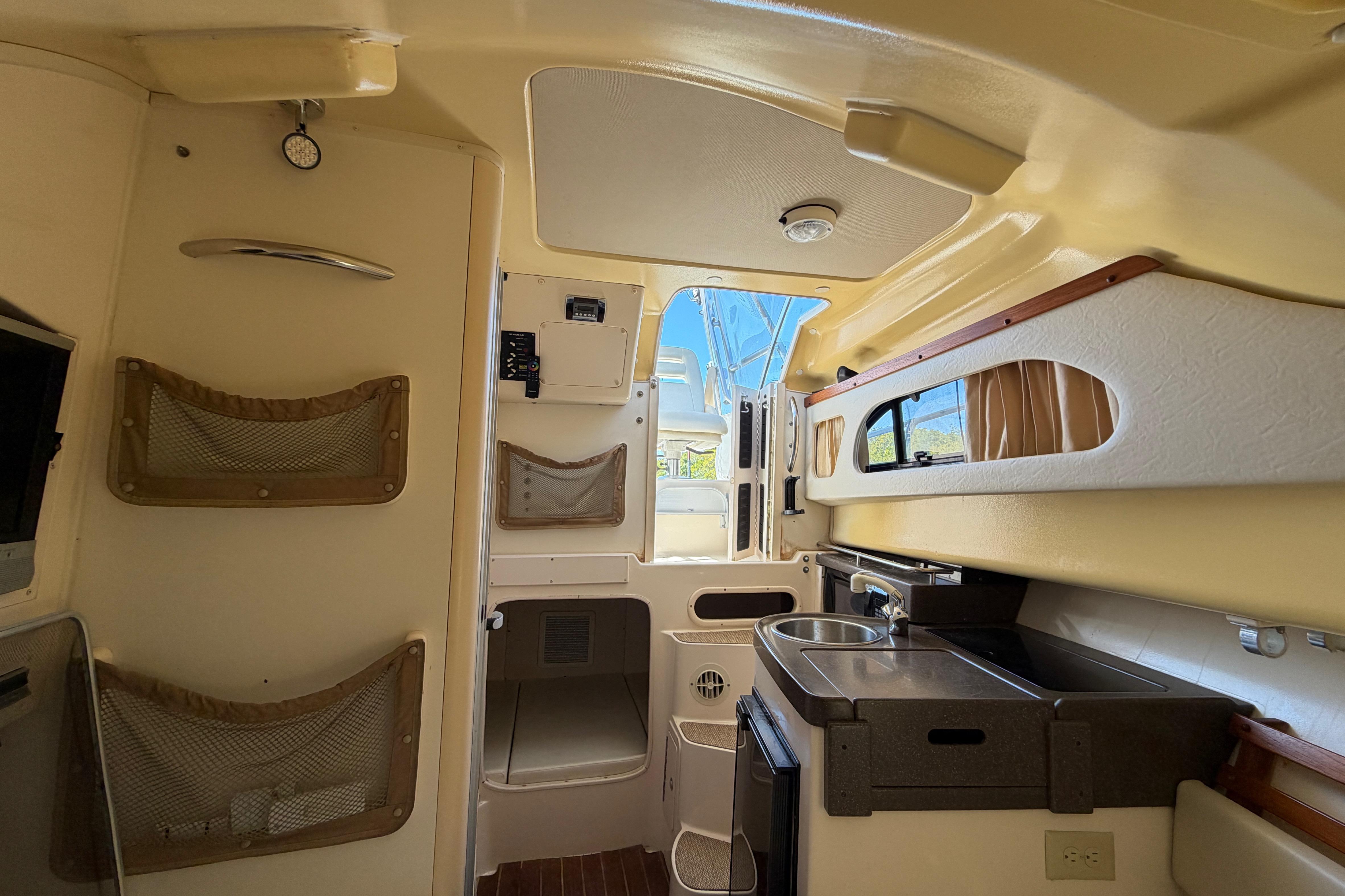 Interior of 2006 Grady-White Sailfish 282 boat, featuring compact kitchen and storage.