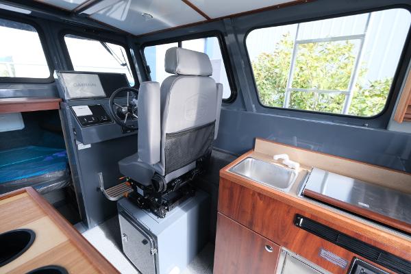 2024 Hewescraft 250 Explorer interior with helm, seating, and kitchenette.