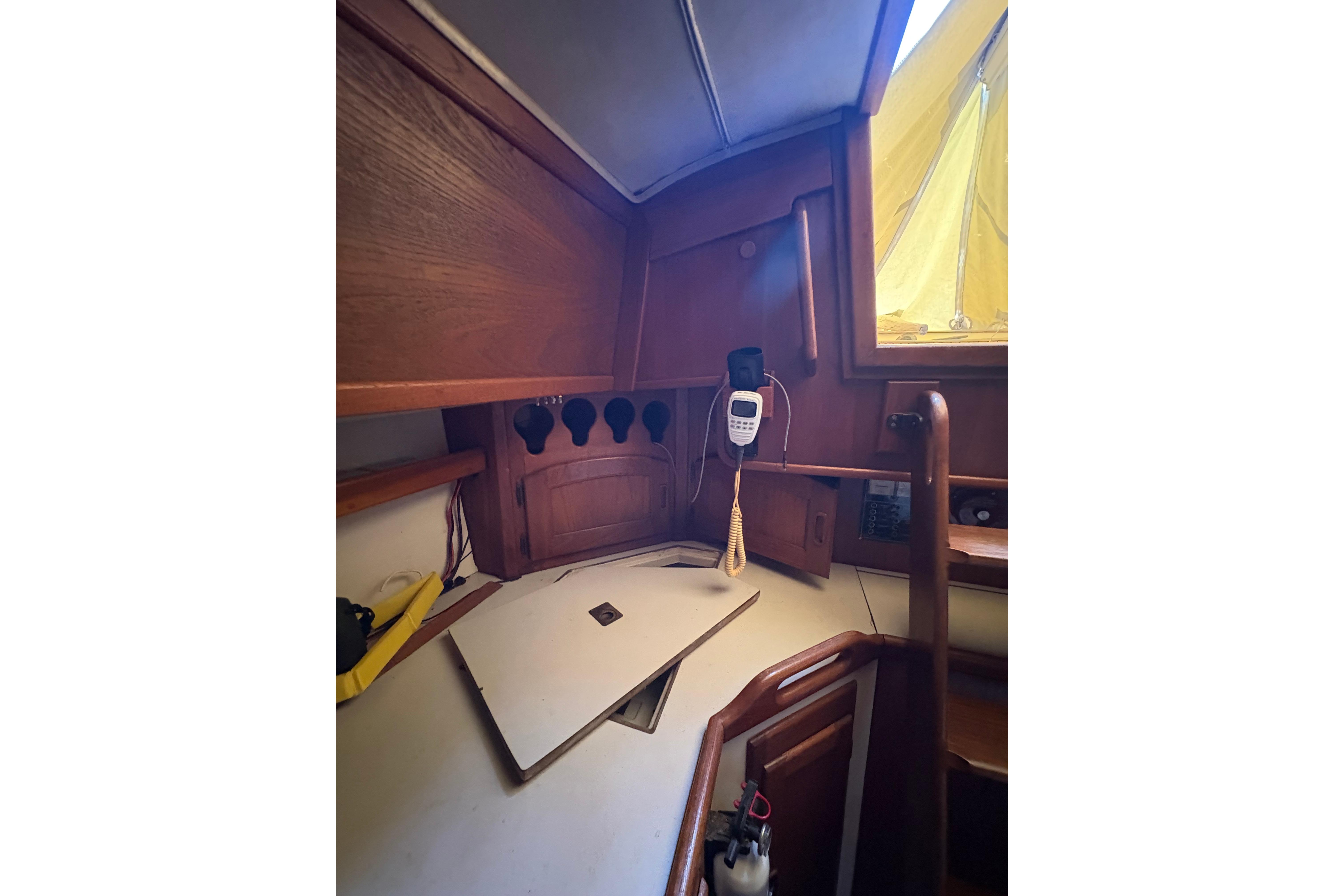 Interior of 1978 Pacific Seacraft 31 sailboat with wooden cabinetry and communication equipment.