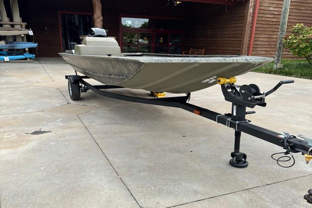 2026 Tracker Grizzly 1648 SC boat on trailer, parked outdoors.