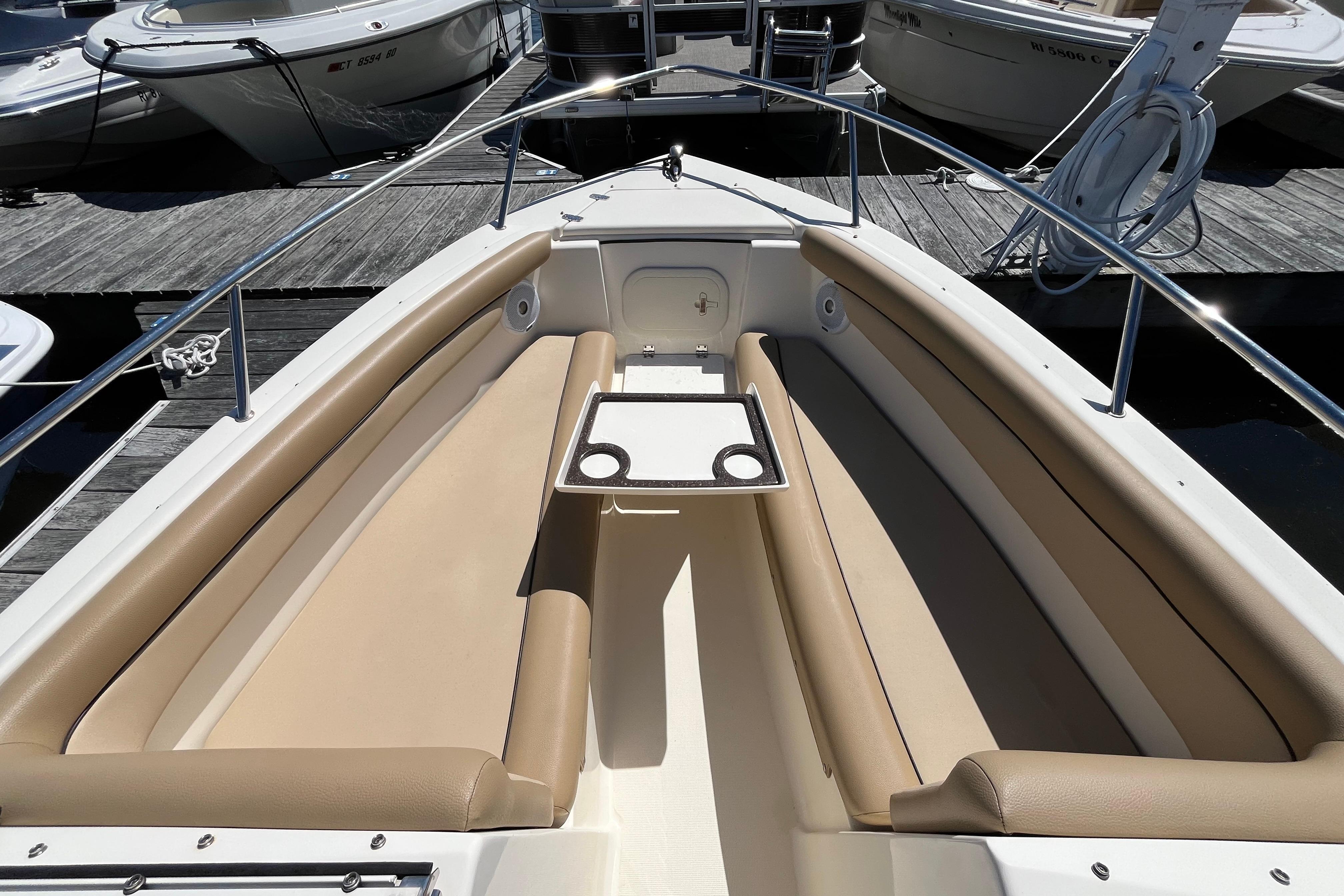 2017 Scout 210 Dorado boat interior with tan seating and table, docked at marina.